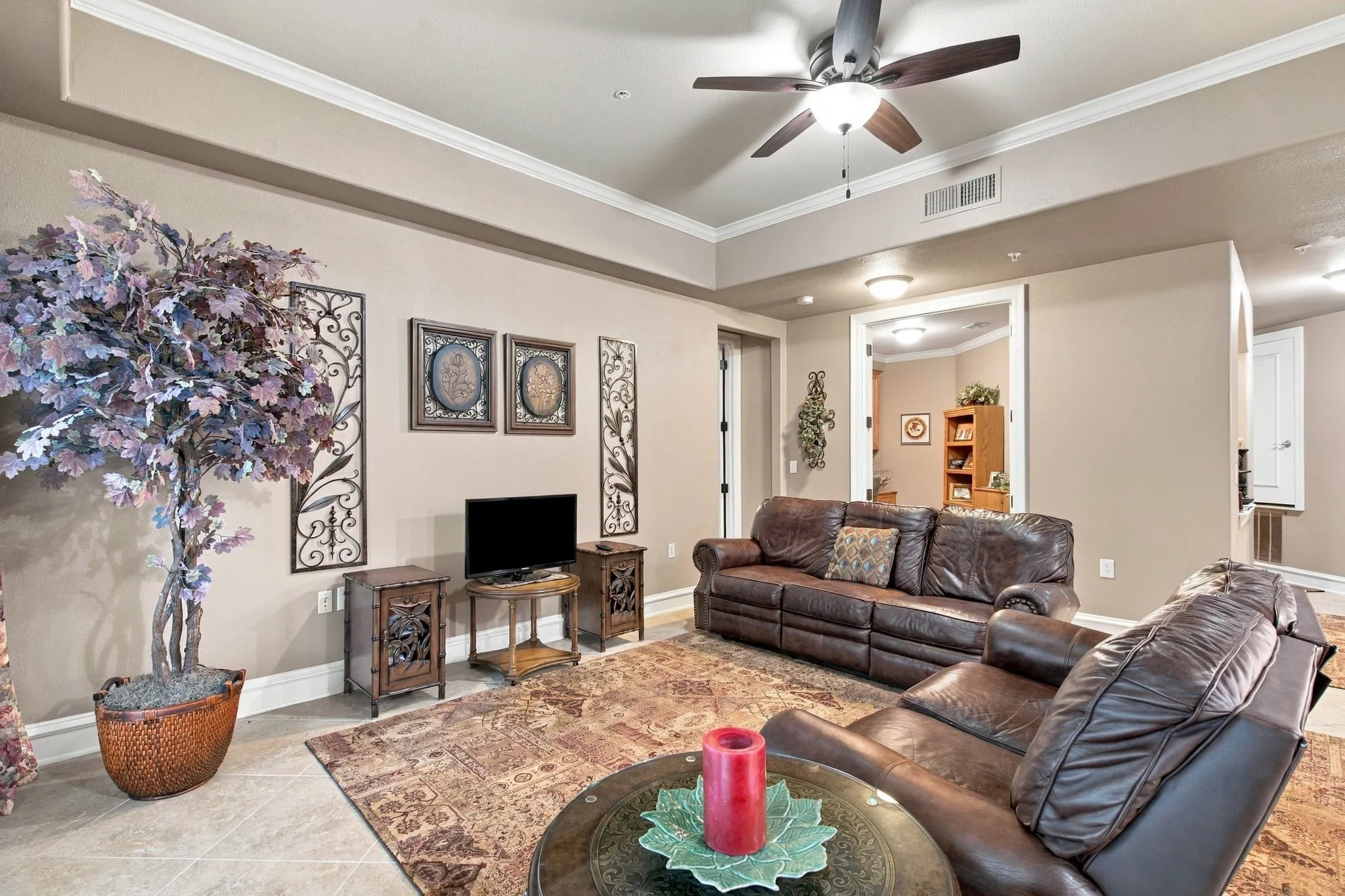 Crown molding, recessed lighting, ceiling fan, tile flooring, and wall sconces