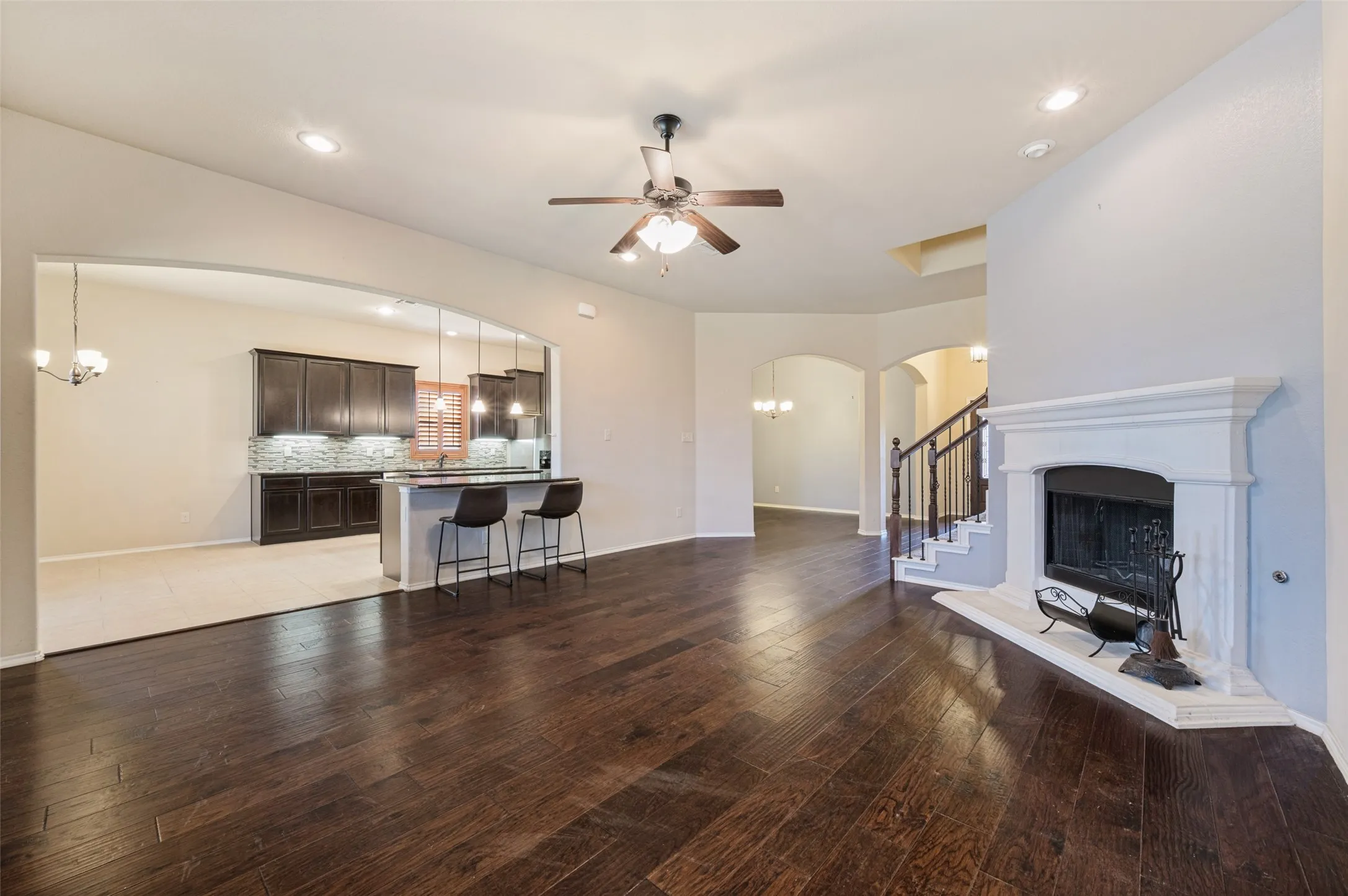 Dark wood-finish flooring, recessed lighting, and ceiling fan