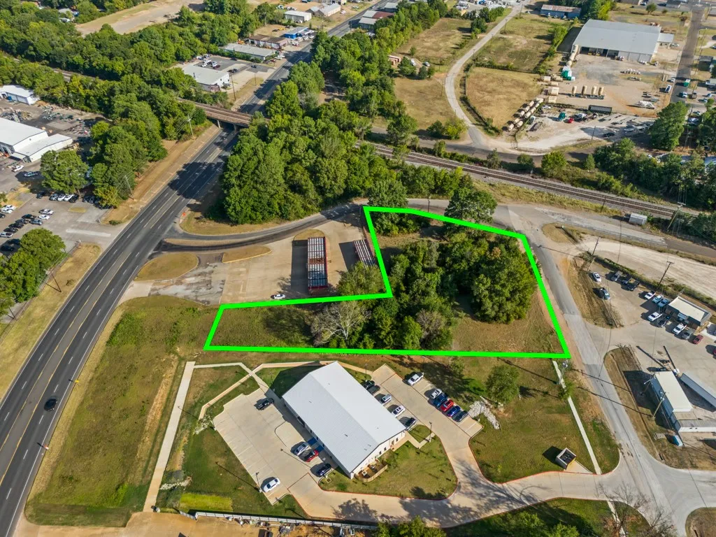 Expansive land parcel featuring direct road access and partial tree coverage