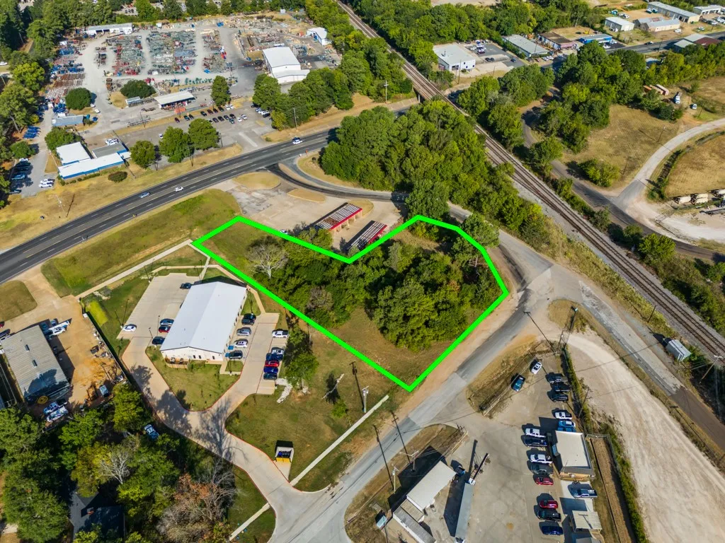 Vacant land parcel featuring mature trees and direct road frontage