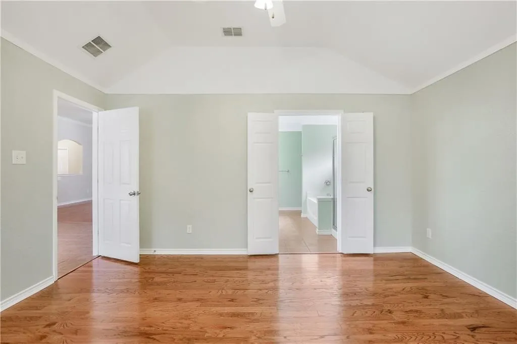 Wood-finish flooring, vaulted ceiling, and white trim