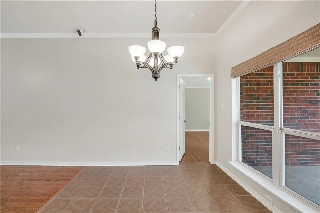 Recessed lighting, crown molding, chandelier, tile flooring, and a large window with blinds