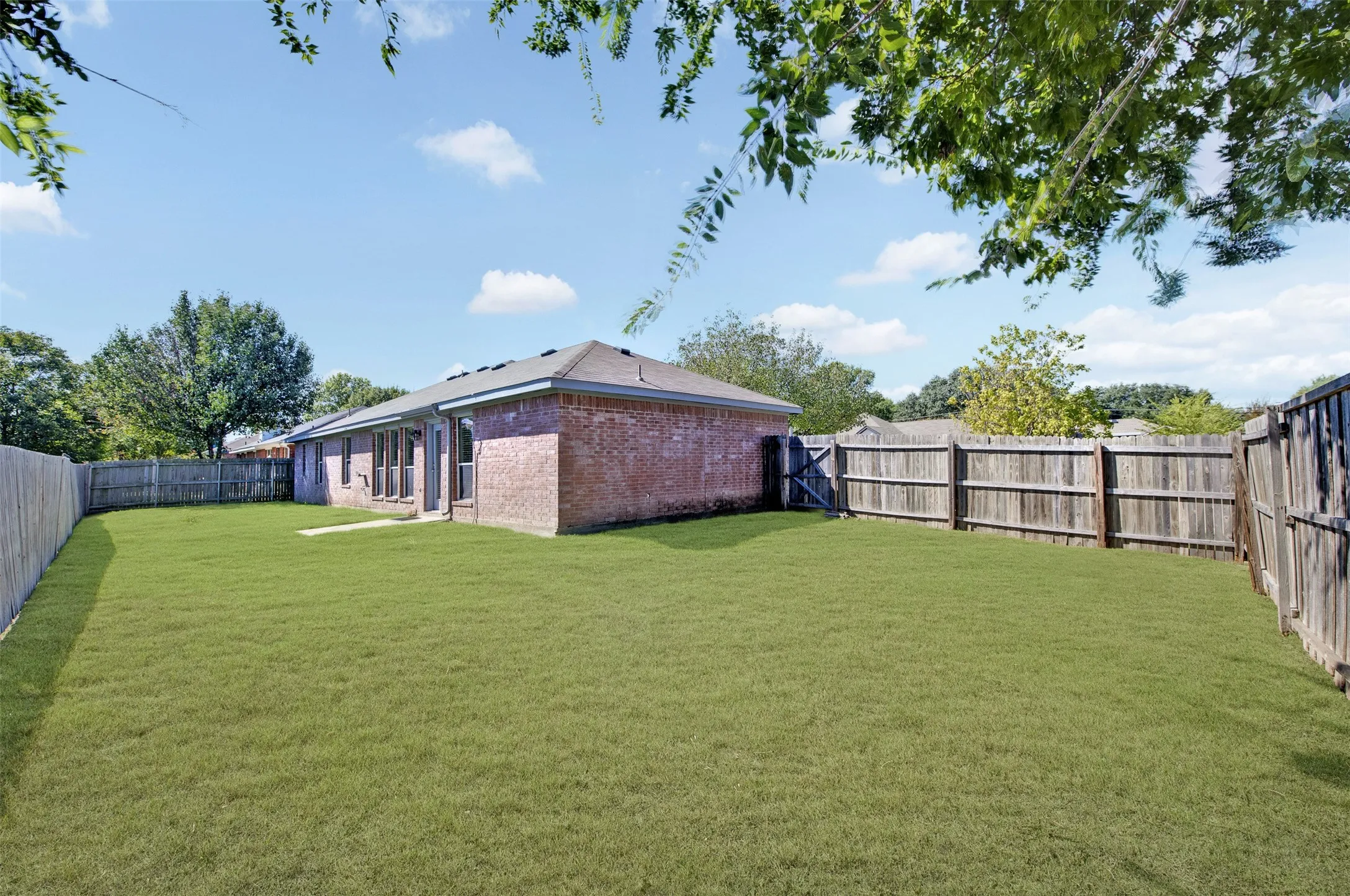 Expansive backyard, fully fenced and a low maintenance brick exterior with multiple windows