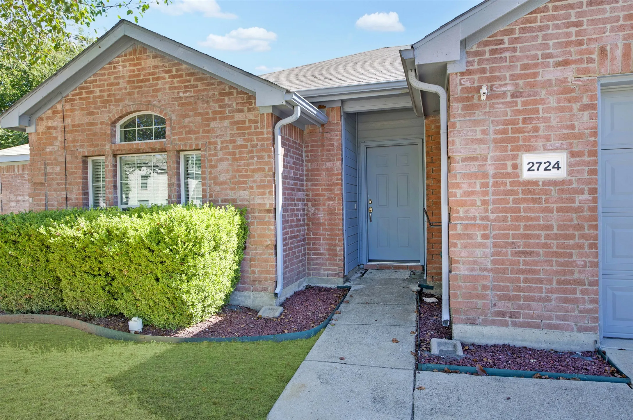 Brick exterior with attractive gray trim, side walk and front door