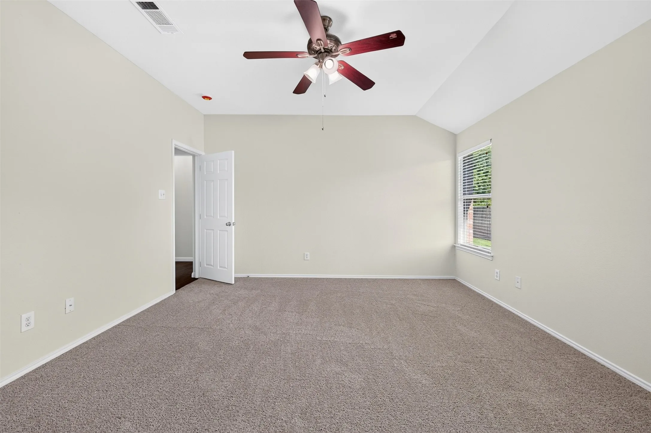 High ceiling with a ceiling fan, neutral wall color, carpet flooring, and a window with blinds