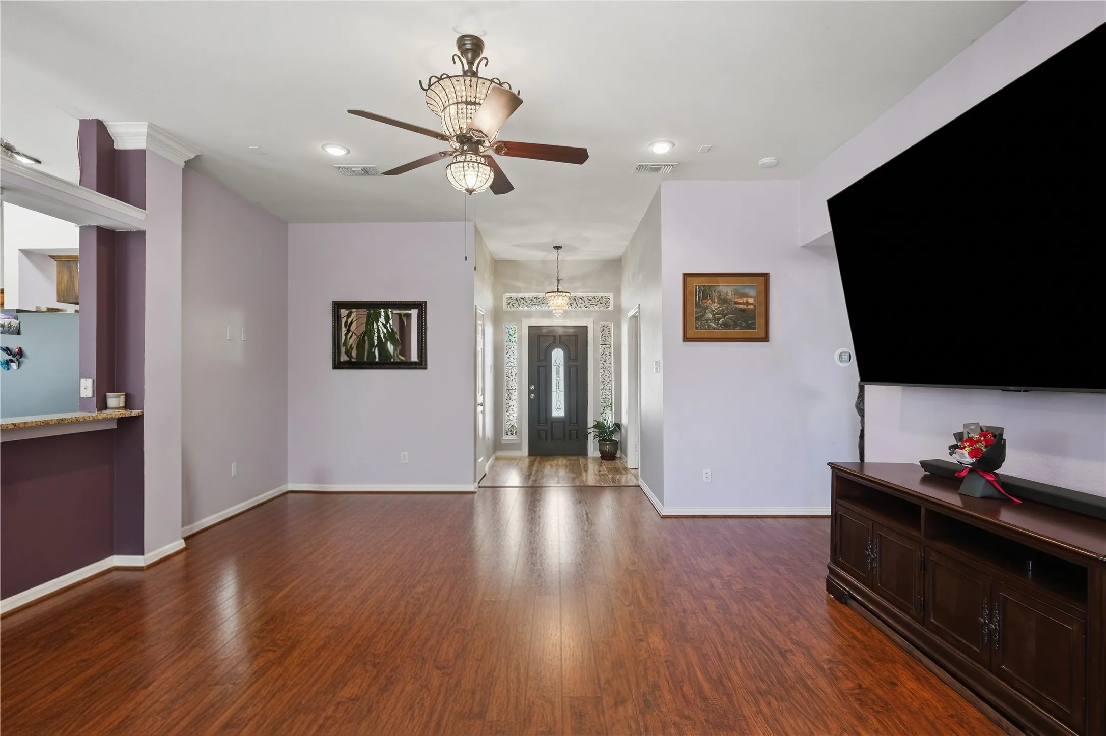 Spacious living area featuring wood-finish flooring, recessed lighting, and a decorative ceiling fan
