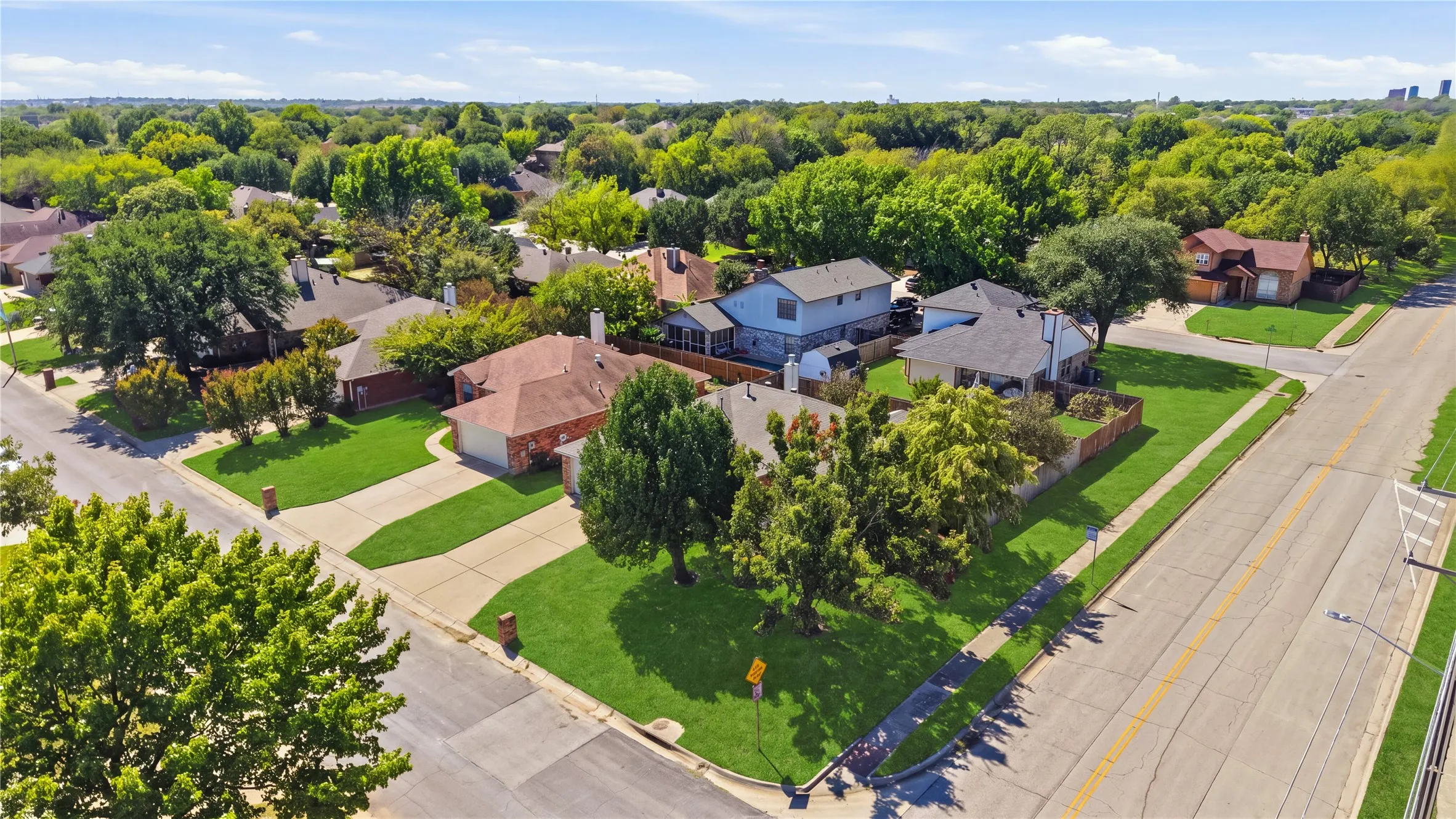 Residential neighborhood with mature trees, established properties, and paved streets