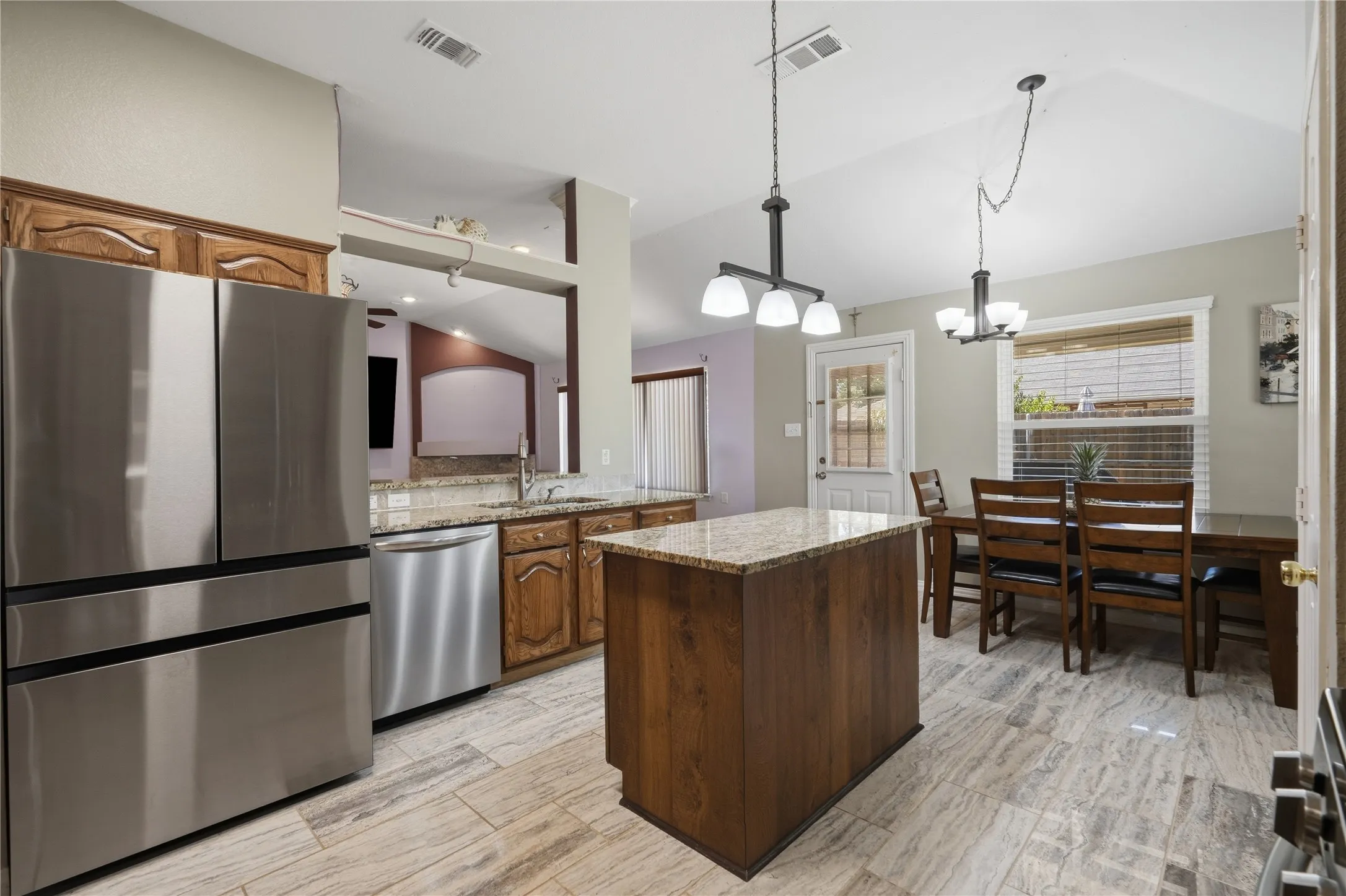 Kitchen featuring wood-finish cabinetry, granite countertops, and stainless steel appliances