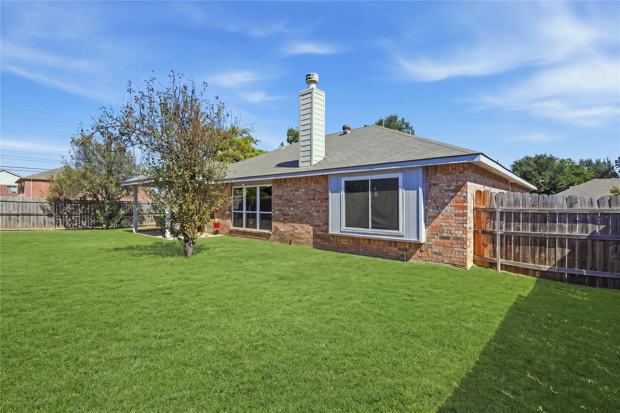 Brick exterior with a gray shingle roof and a prominent chimney