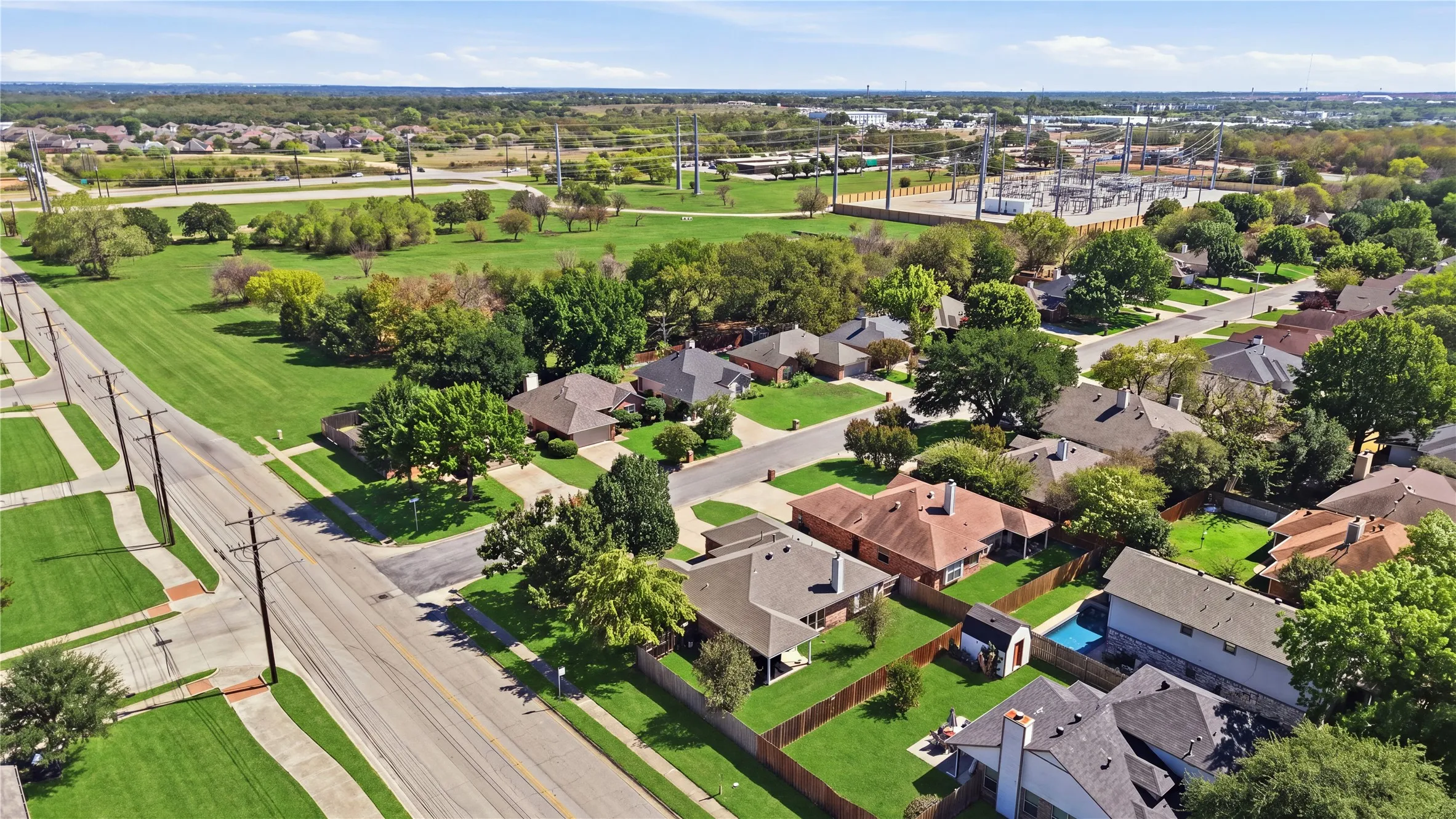 Residential neighborhood with mature trees, established roadways, and green spaces