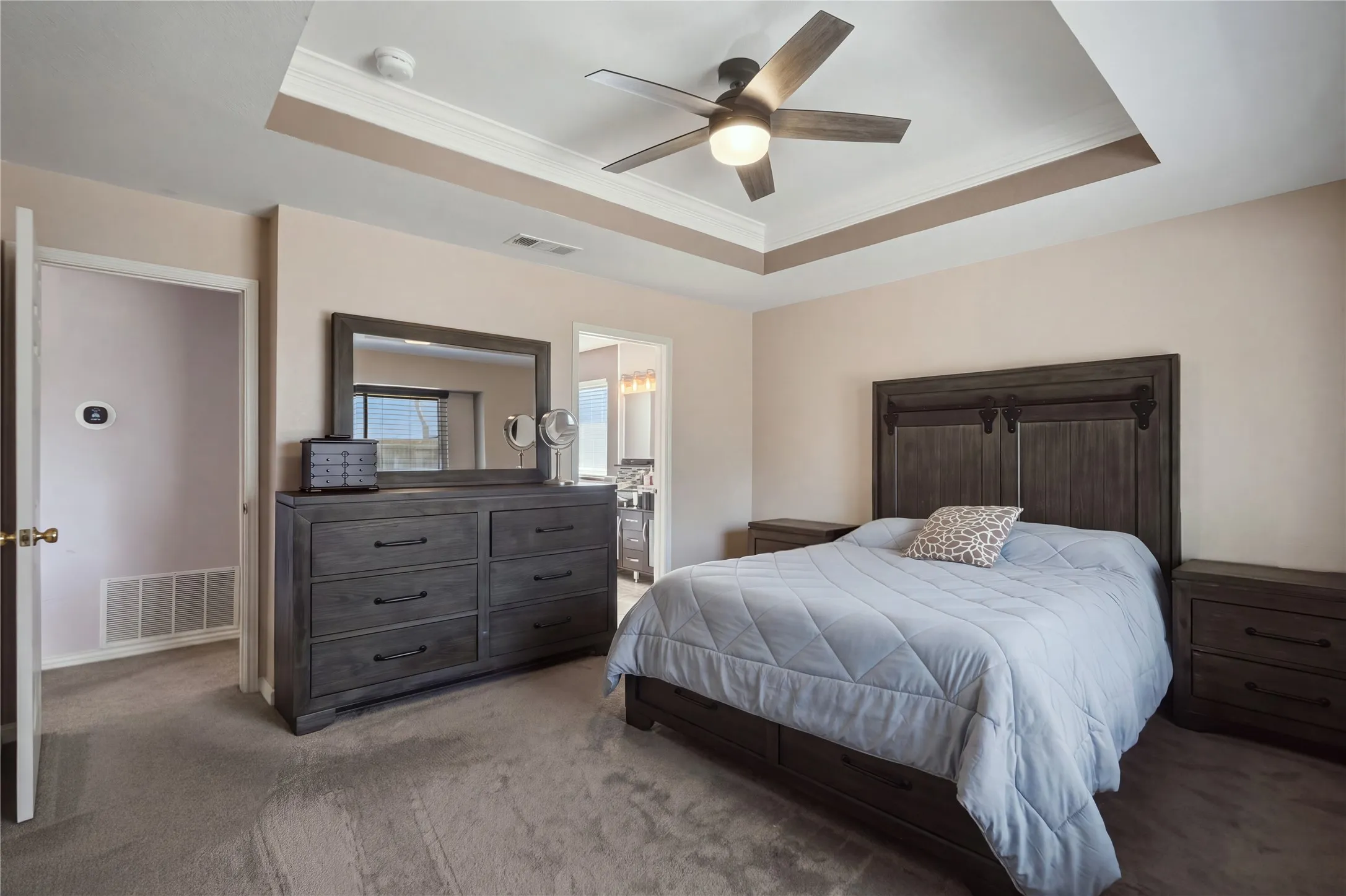 Tray ceiling with crown molding and a ceiling fan