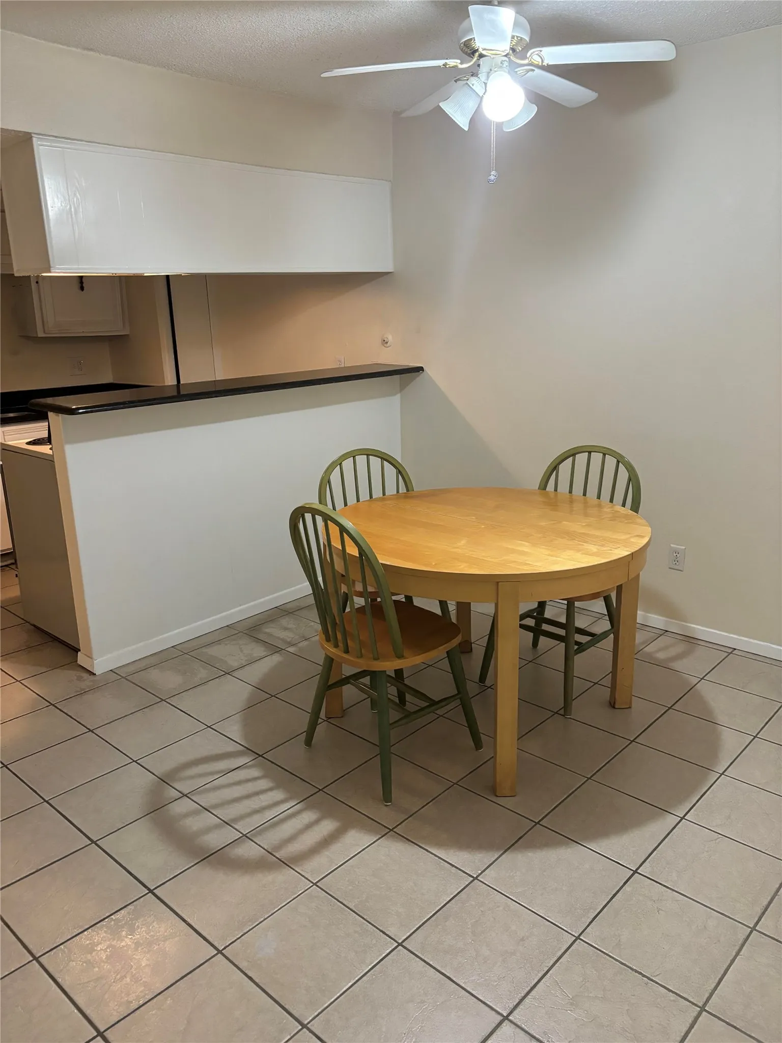 Tiled dining space featuring ceiling fan