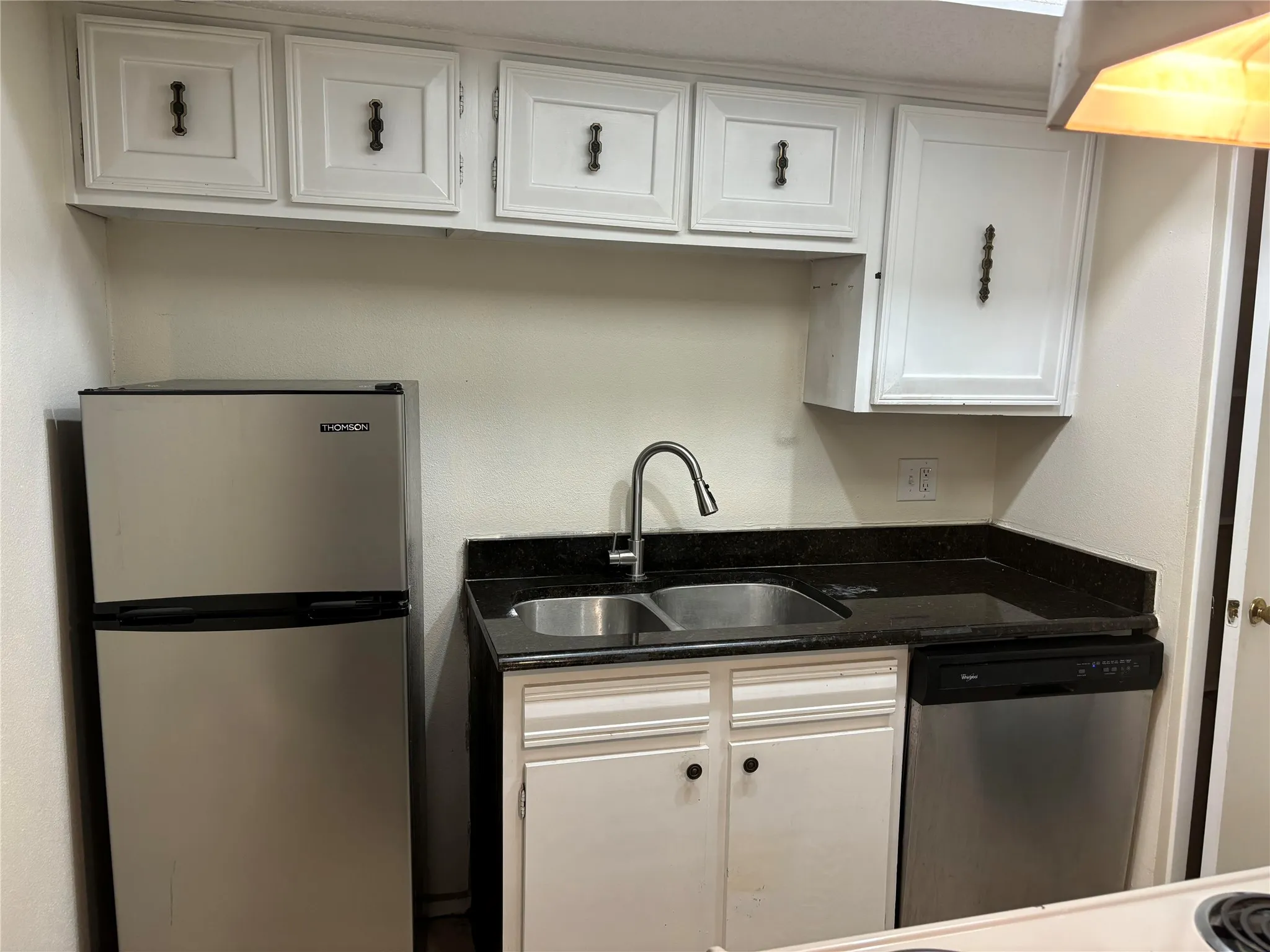 Kitchen featuring sink, white cabinets, and appliances with stainless steel finishes