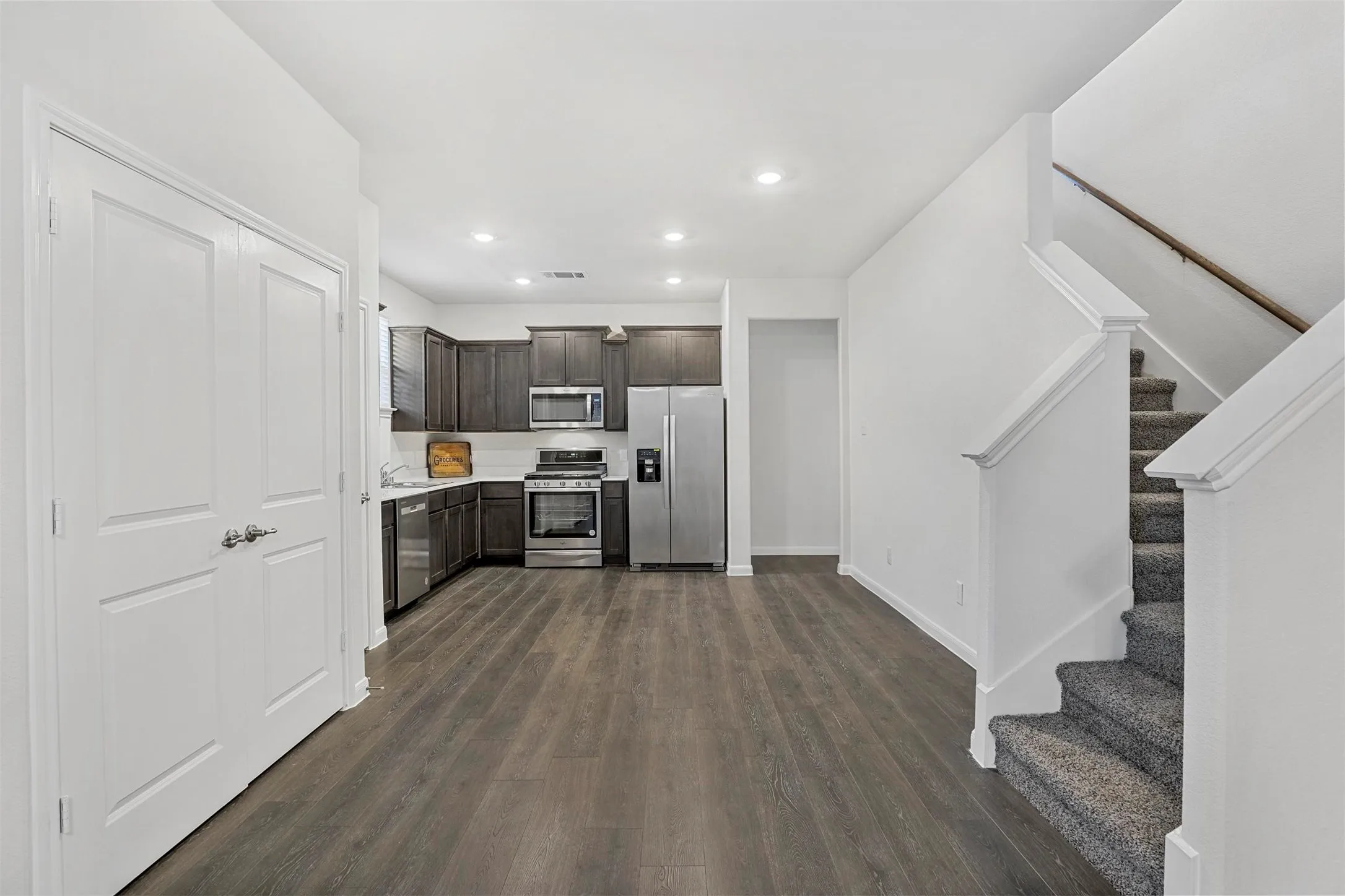 Kitchen featuring dark wood cabinetry, stainless steel appliances, and built-in microwave