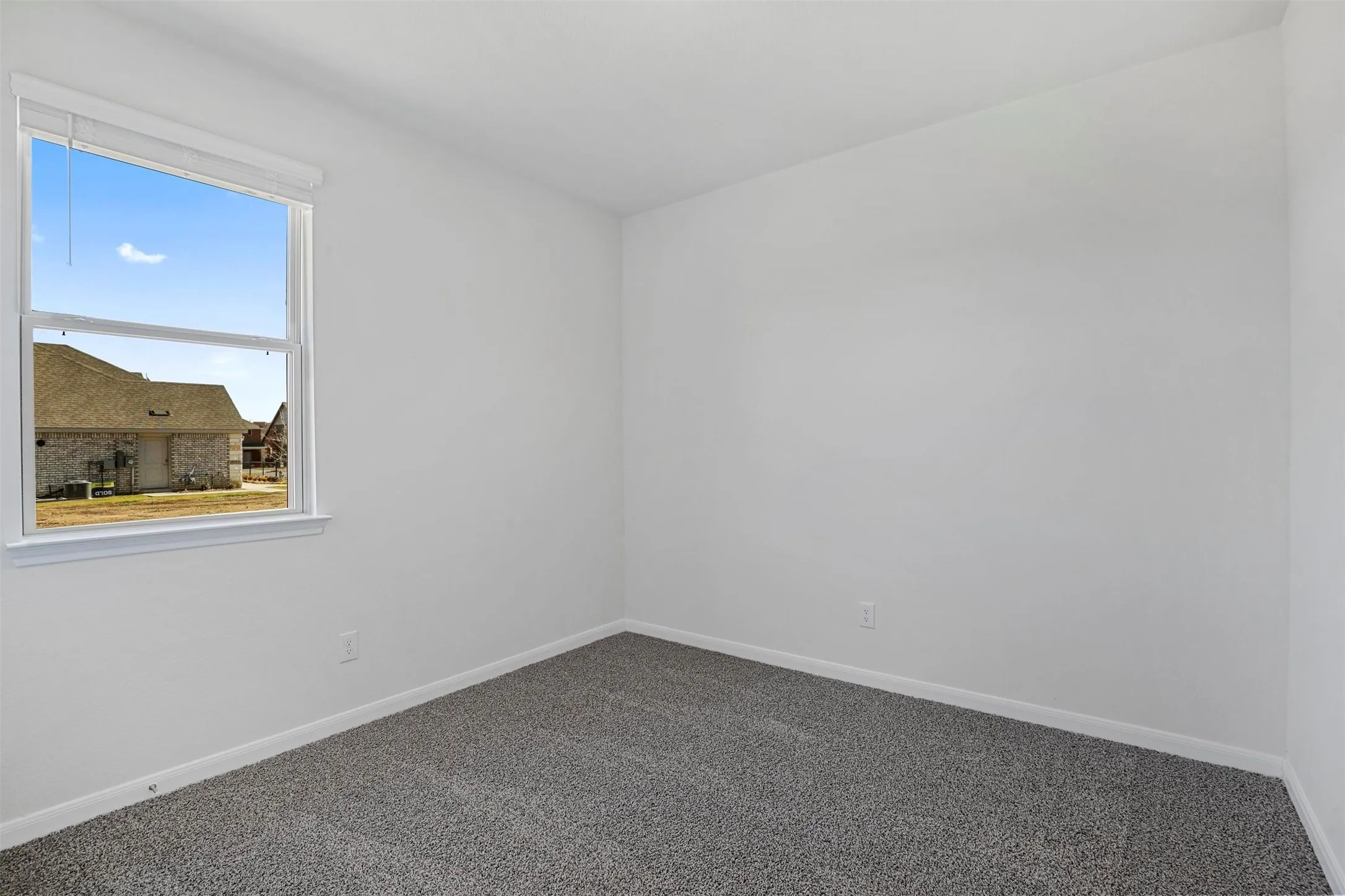 Neutral wall paint, ceiling-mounted light fixture, single window, and carpeted flooring