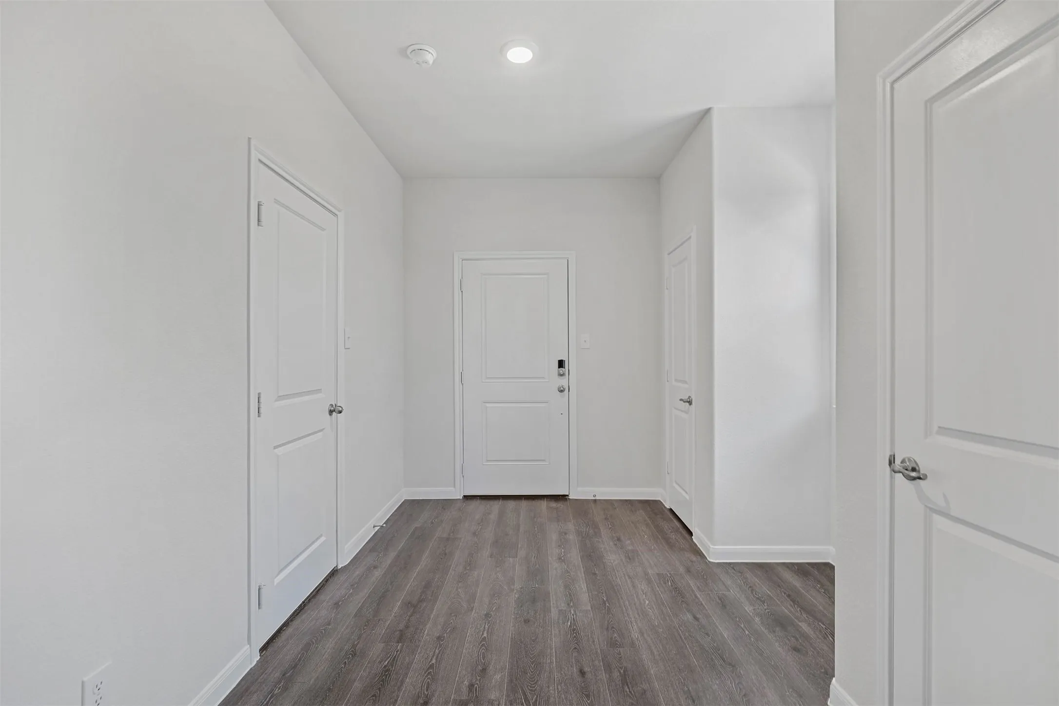 Wood-finish flooring with white trim and white walls