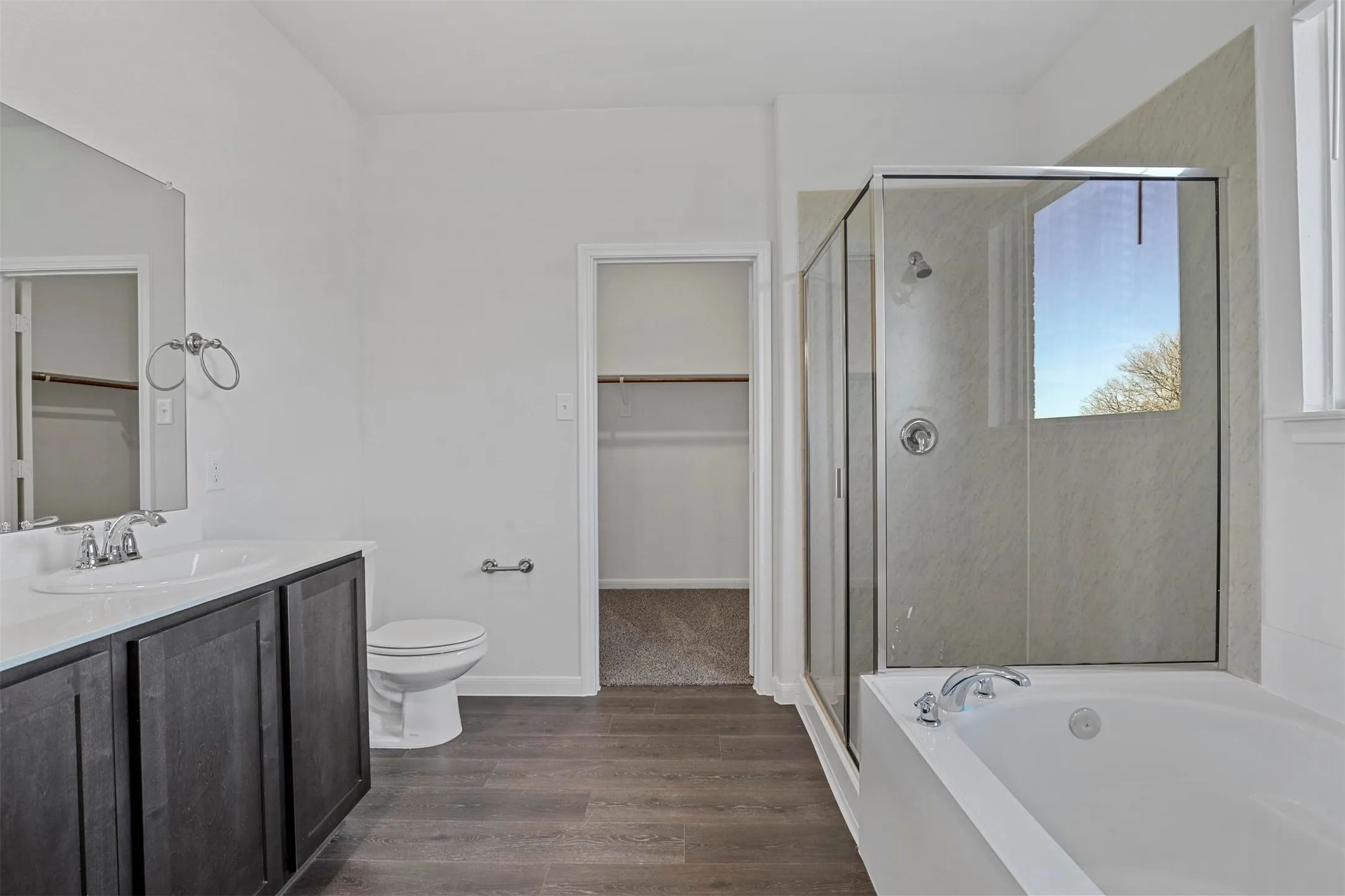 Dark wood-finish vanity with an integrated sink, white countertop, and chrome fixtures