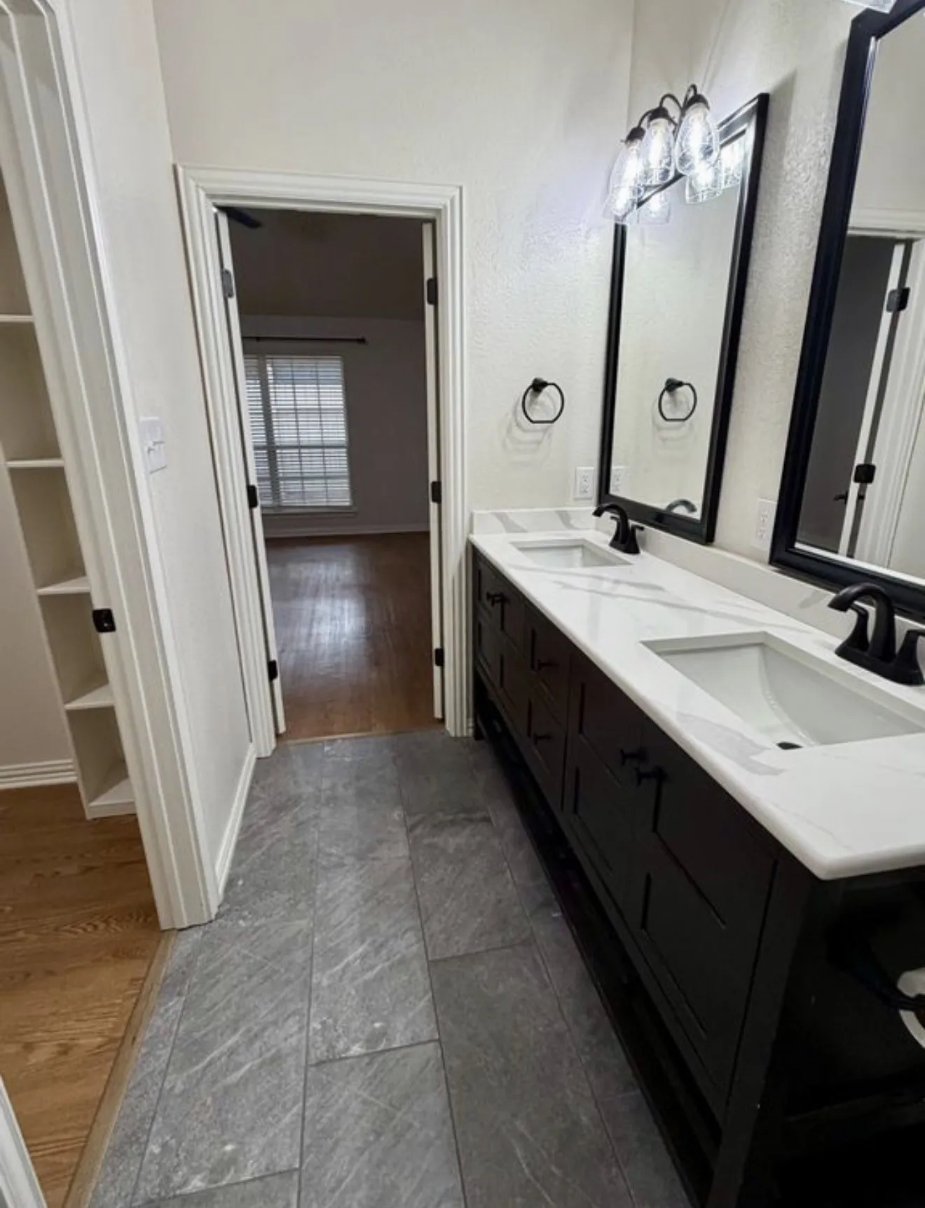 Dual vanity with white countertops, undermount sinks, and matte black fixtures