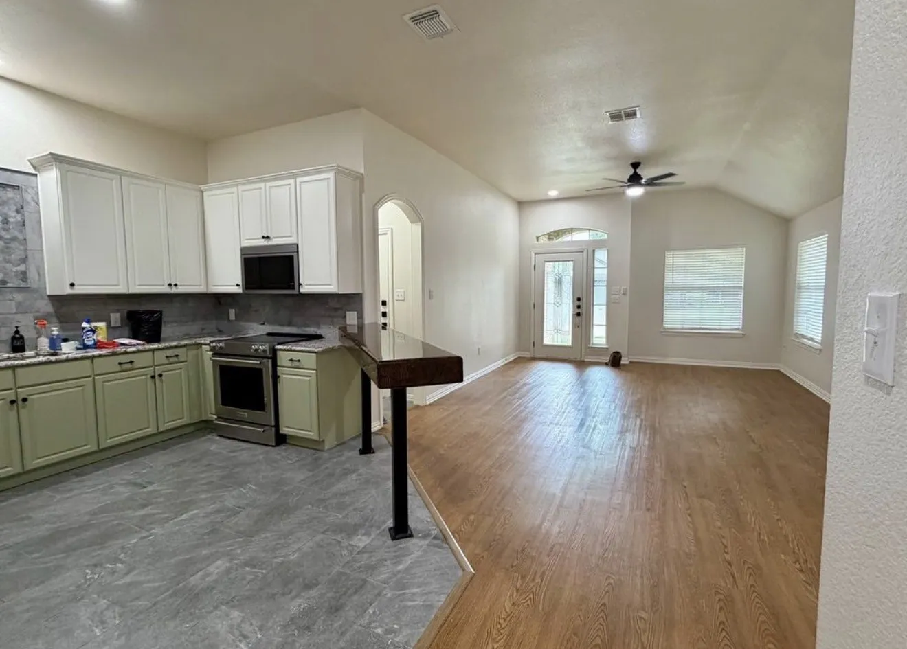 Kitchen with stainless steel appliances, stone-finish countertops, and a tile backsplash