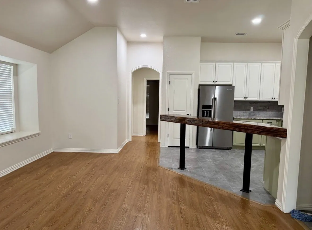 Wood-finish flooring, recessed lighting, and an arched doorway