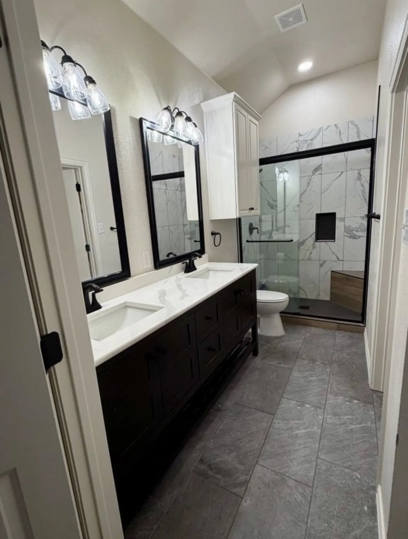 Dual vanity with white undermount sinks, matte black faucets, and a white countertop