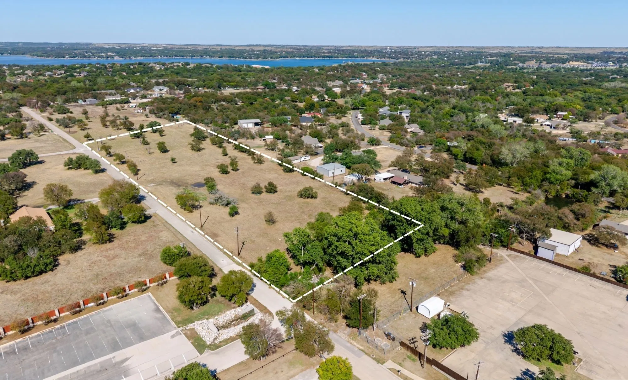 Expansive undeveloped lot featuring mature trees and a paved road