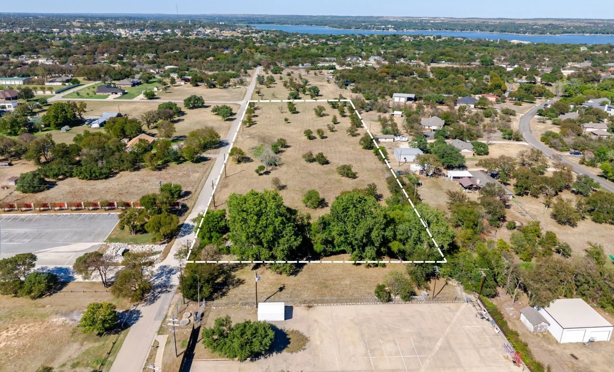 Expansive undeveloped lot with varied terrain, mature trees, and natural vegetation
