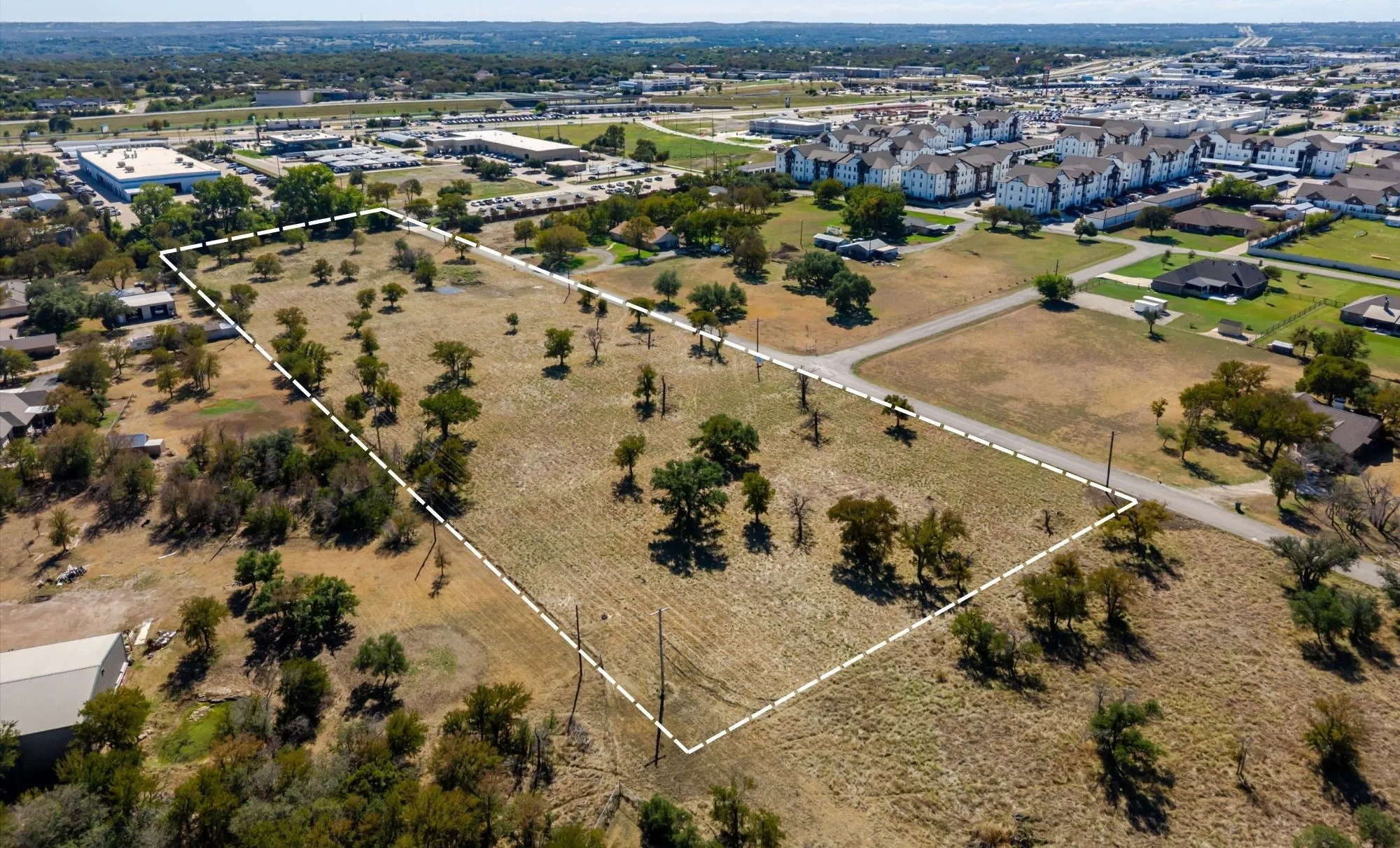 Expansive undeveloped land featuring mature trees and a perimeter outline