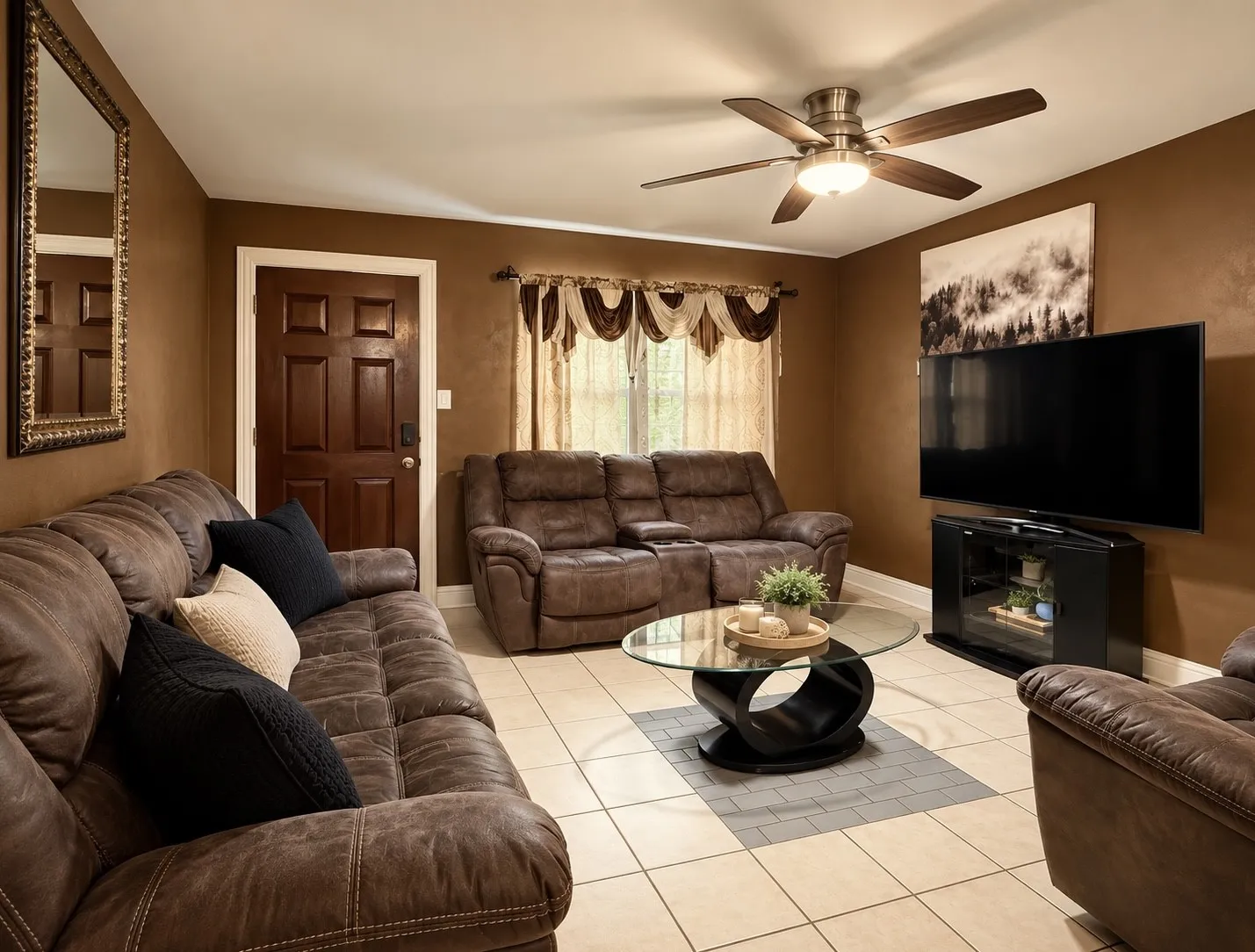 Ceiling fan with integrated lighting, tiled flooring, warm-toned walls, six-panel interior door, and a window with valance
