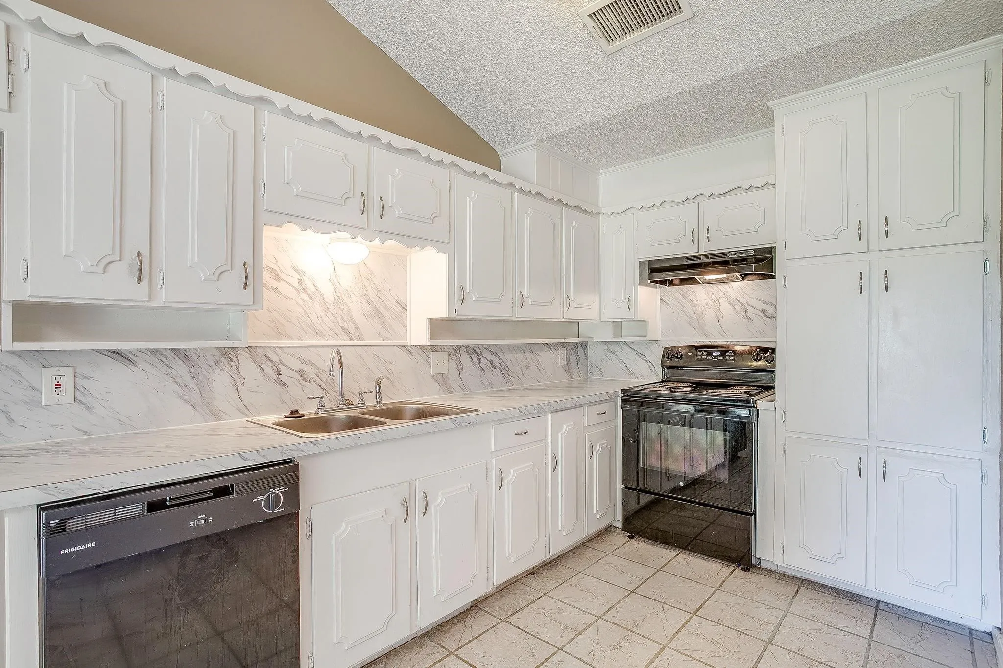 Kitchen featuring white cabinetry, built-in black dishwasher, black range, dual basin sink, and tile flooring