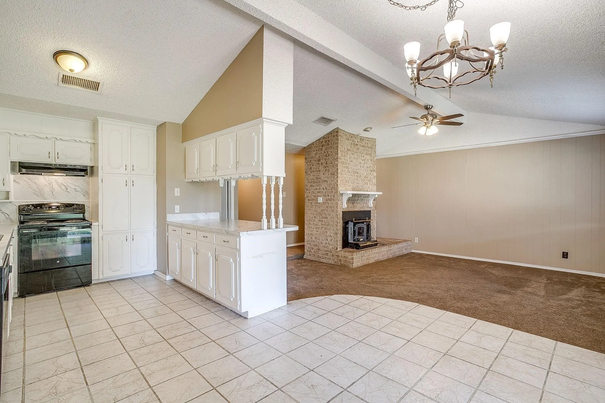 Kitchen featuring white cabinetry, tile flooring, a black range, and stone-finish countertops