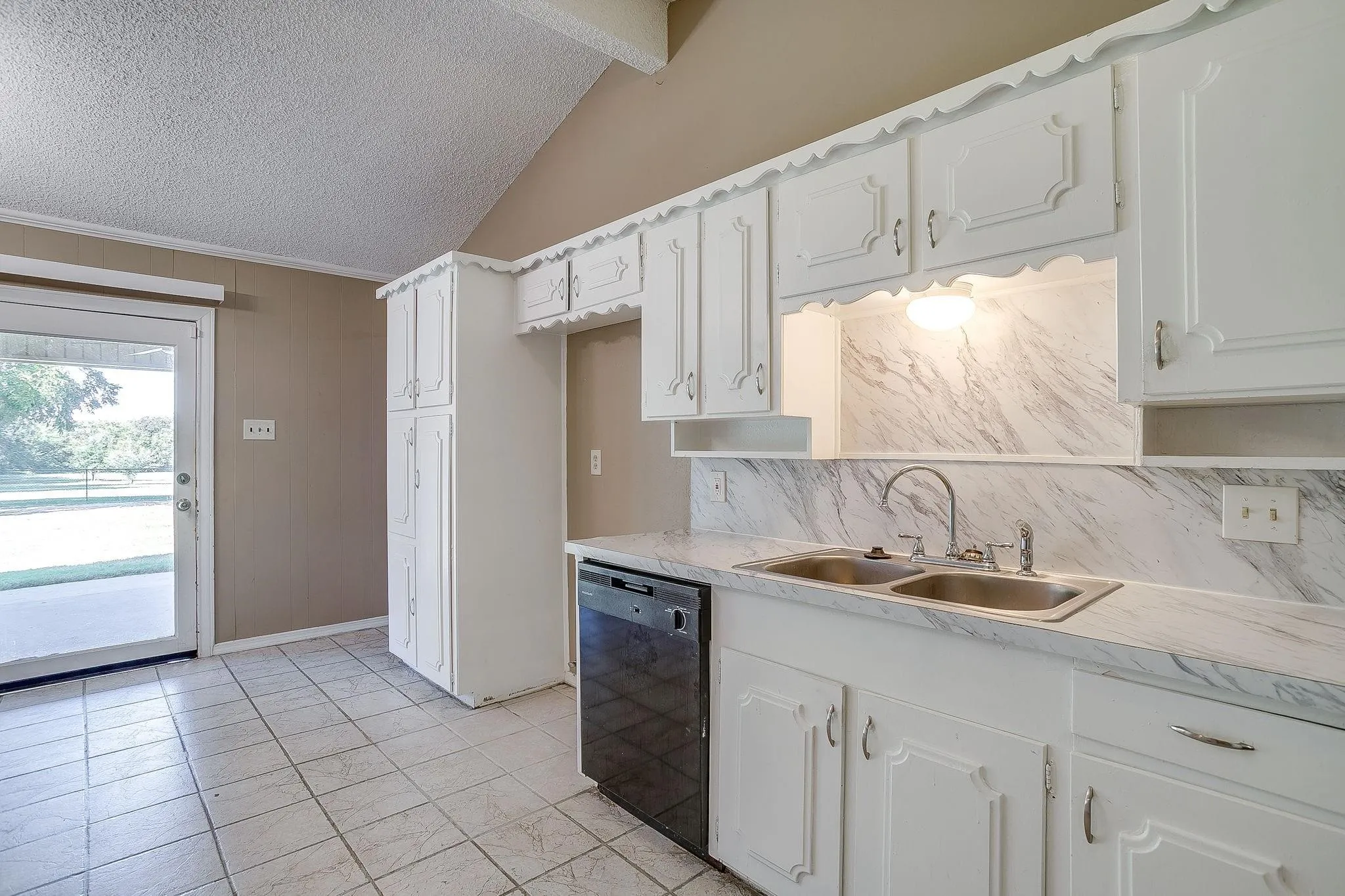 White cabinetry with decorative trim, dual basin stainless steel sink, black built-in dishwasher, and marbled countertops
