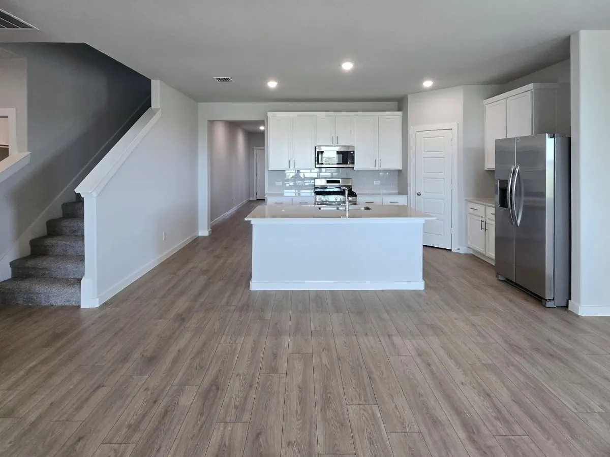 Contemporary kitchen with stainless steel appliances, white cabinetry, and a central island