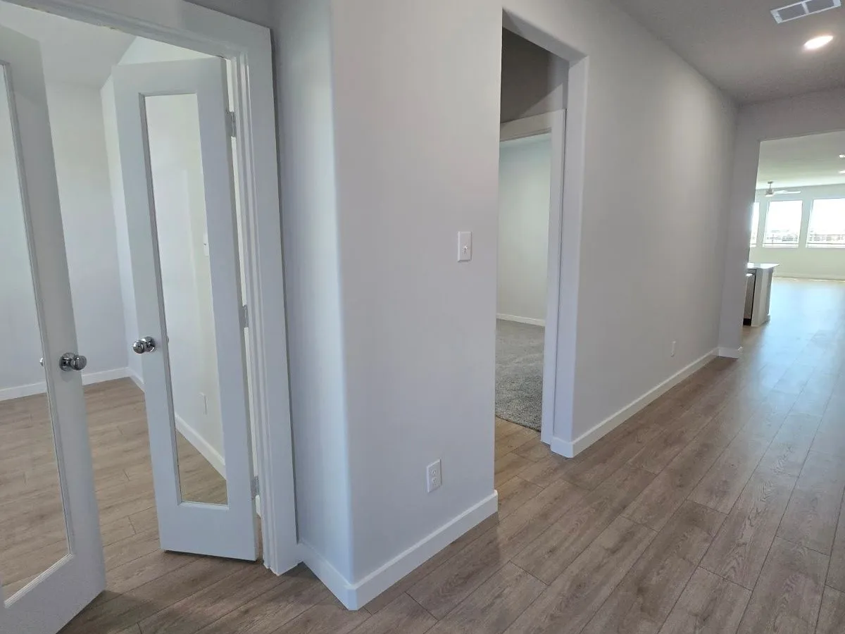 Wood-finish flooring throughout, bright white trim, and light gray wall paint