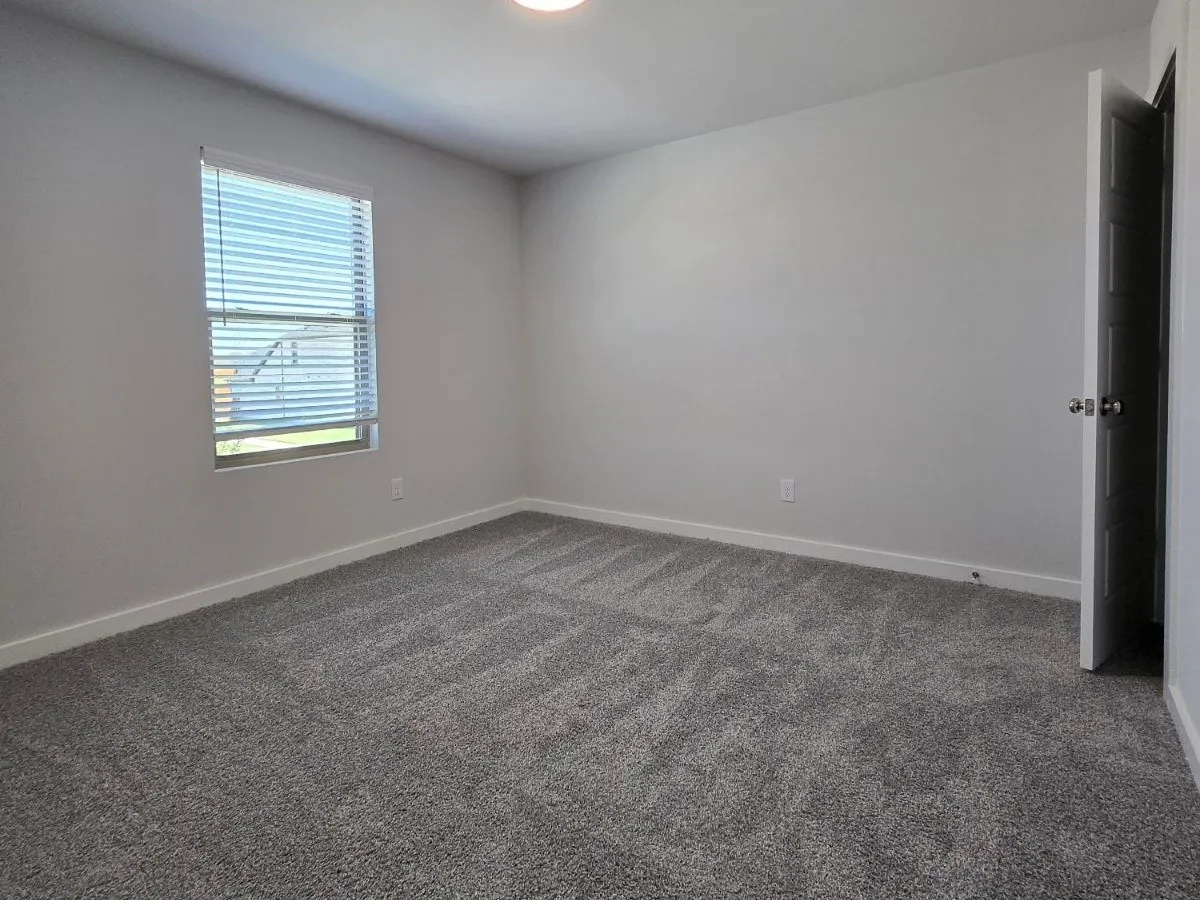 Recessed lighting illuminates neutral-toned walls and plush carpet