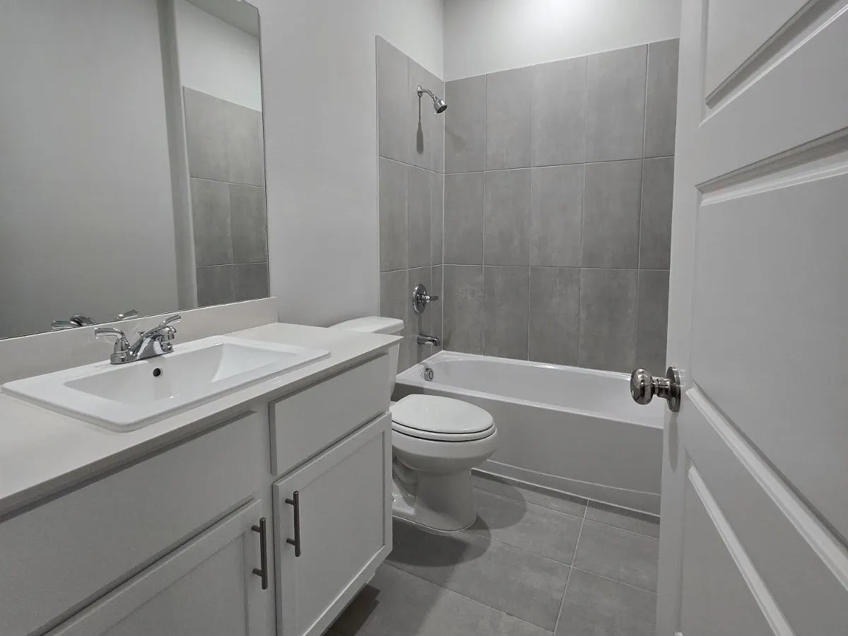White vanity with integrated sink, chrome faucet, and rectangular mirror