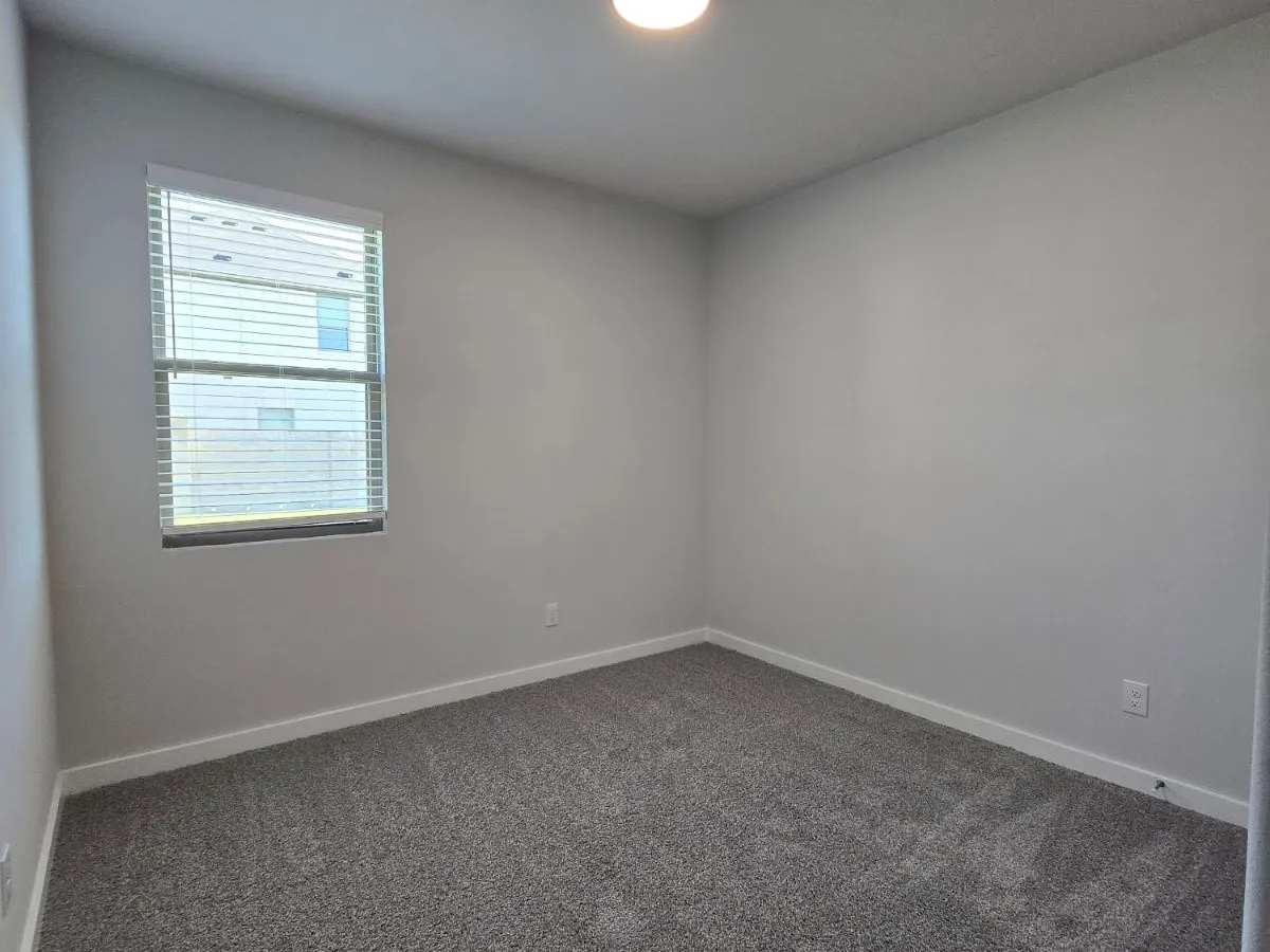 Neutral-toned walls complement the gray carpeting