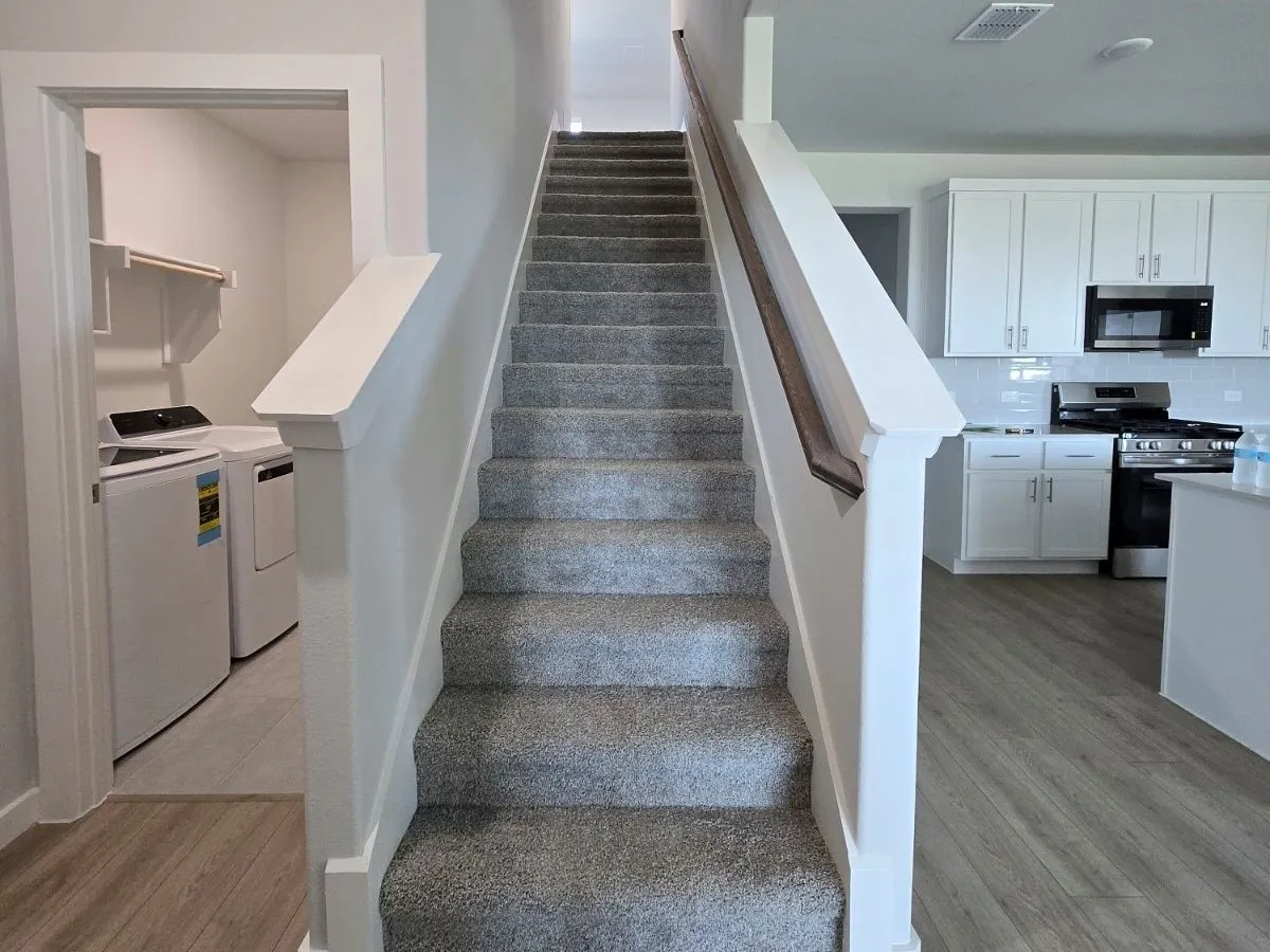 Carpeted staircase with a wood-finish handrail