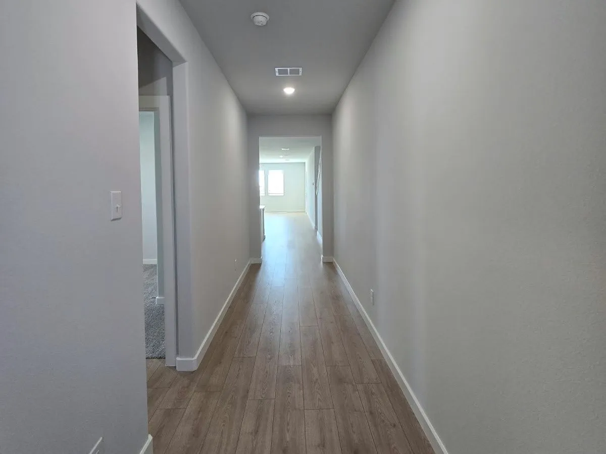 Hallway with wood-finish flooring, recessed lighting, and neutral wall paint
