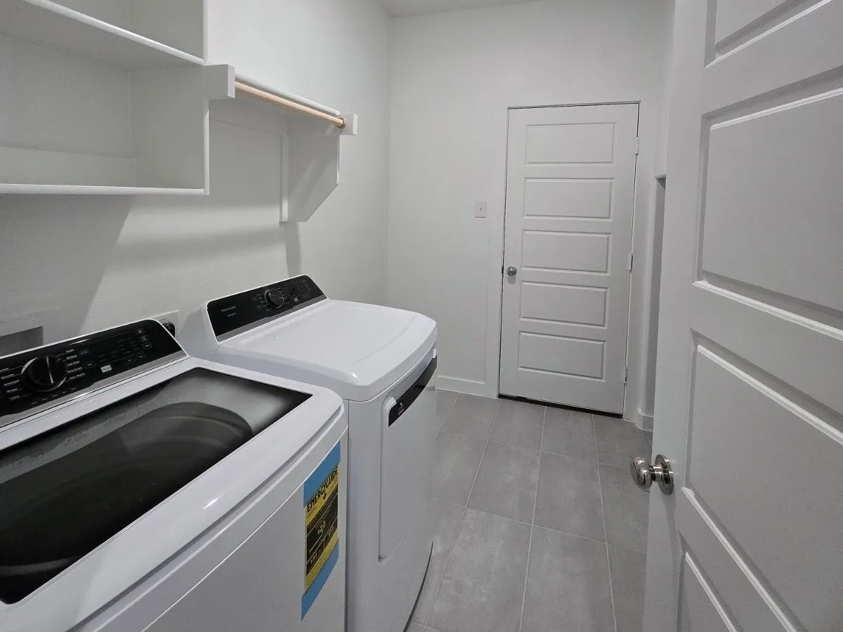 Built-in shelving, hanging rod, and light-toned tile flooring