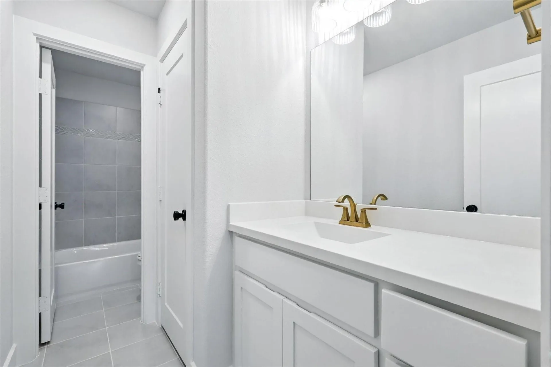 Vanity with a white countertop and gold-finish faucet