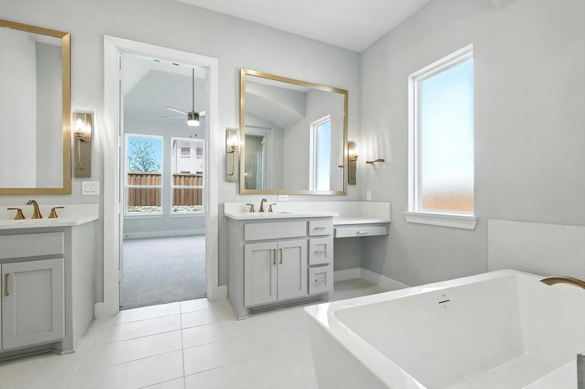 Dual vanities with integrated sinks, framed mirrors, and wall sconces