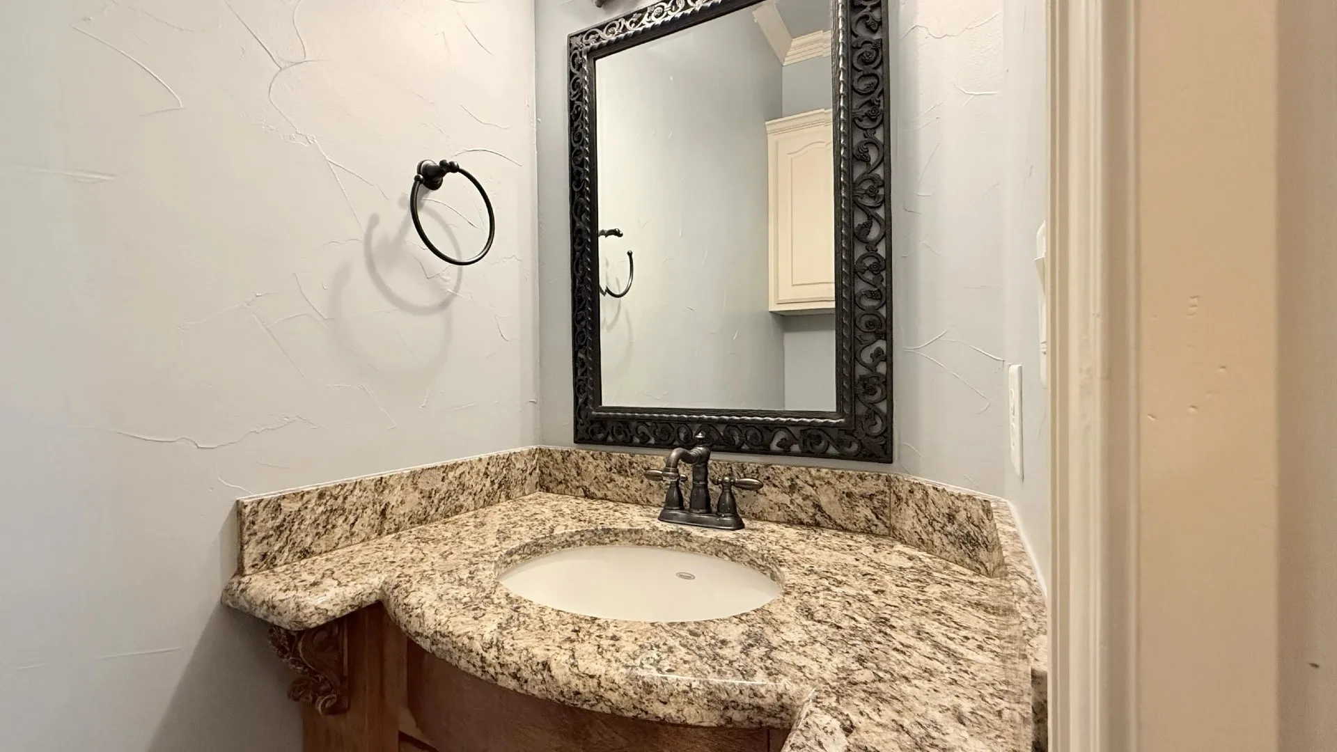 Built-in vanity with a stone countertop and an undermount sink