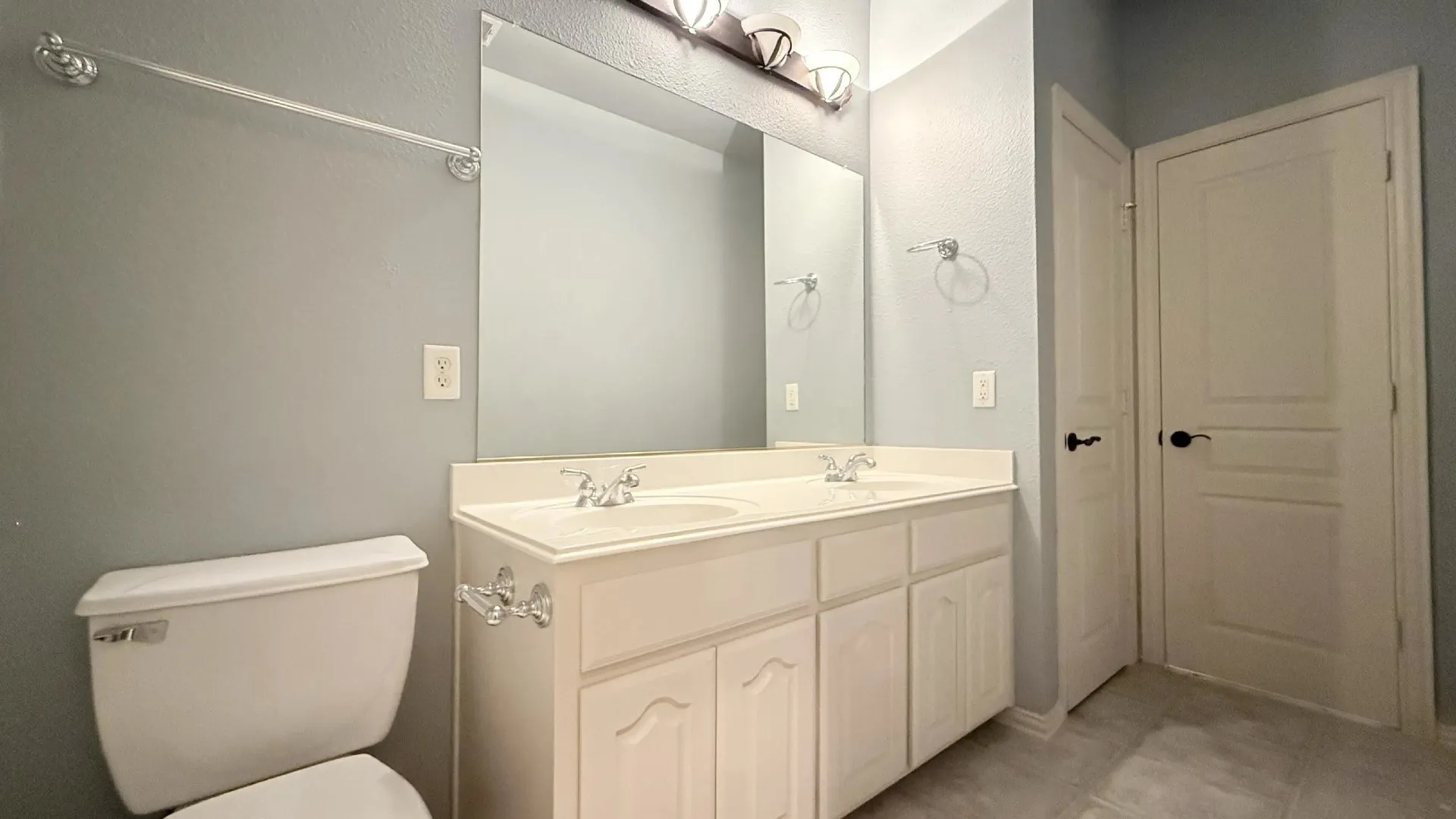 Dual vanity with white cabinetry and integrated sinks, complemented by chrome fixtures