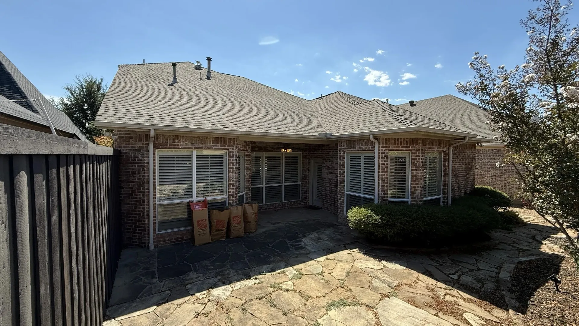 Brick exterior with a shingle roof and white gutters