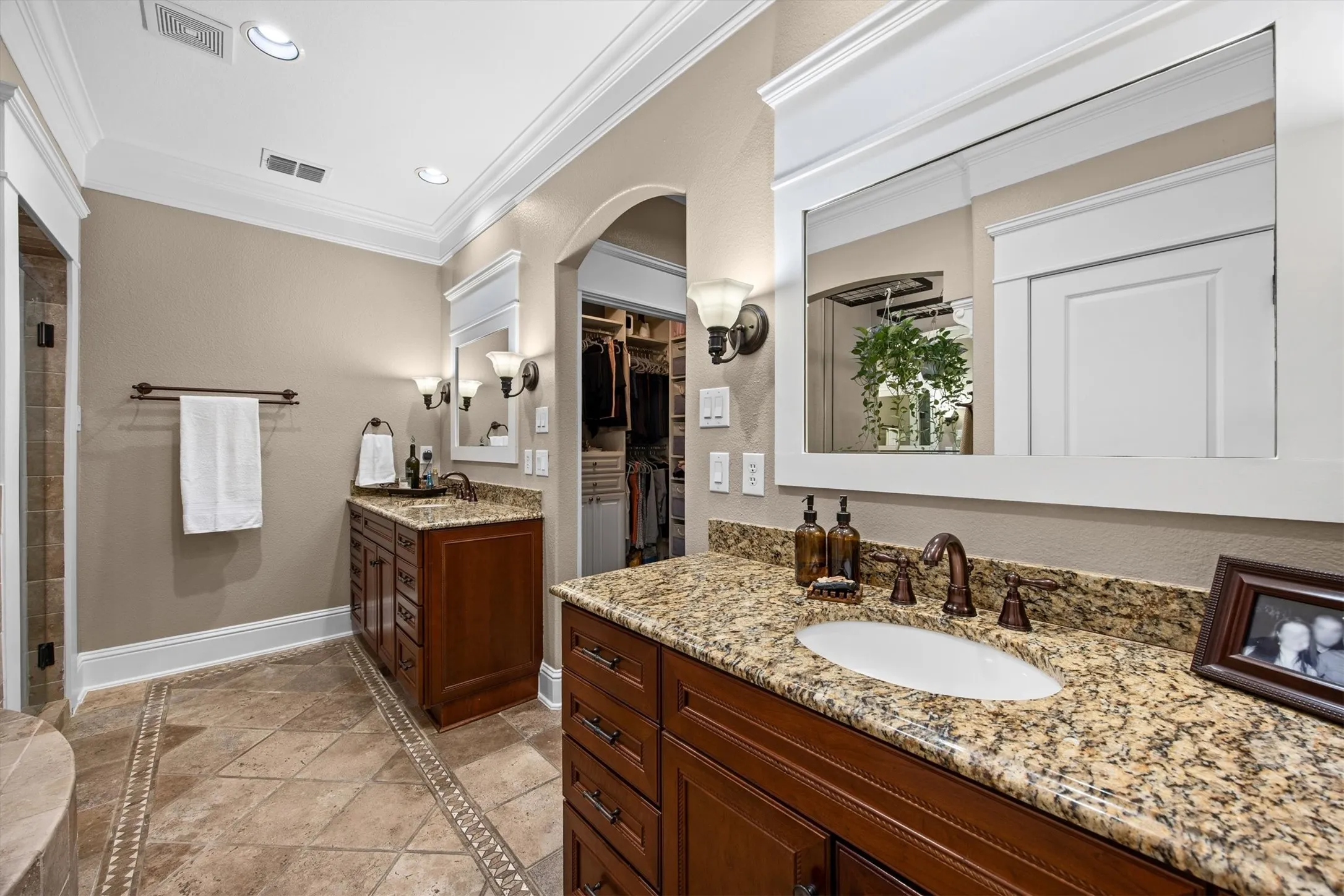 Primary bathroom with dual, separate vanities.
