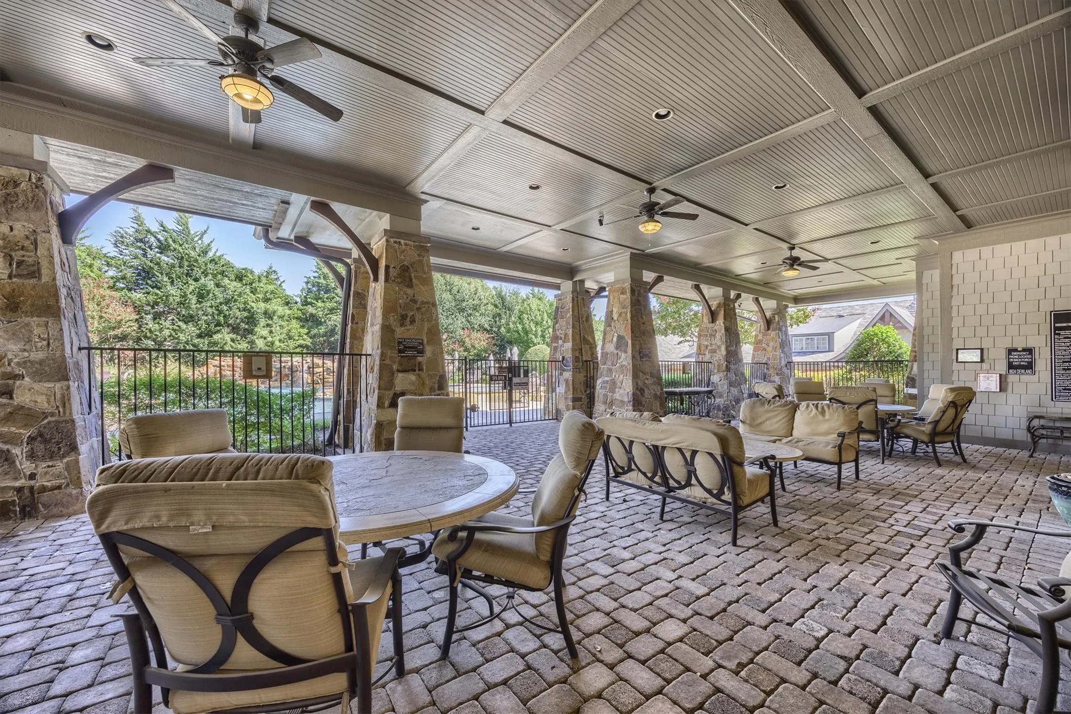 Covered patio featuring a beadboard ceiling, recessed lighting, ceiling fans, stone-clad pillars, and a paver stone floor