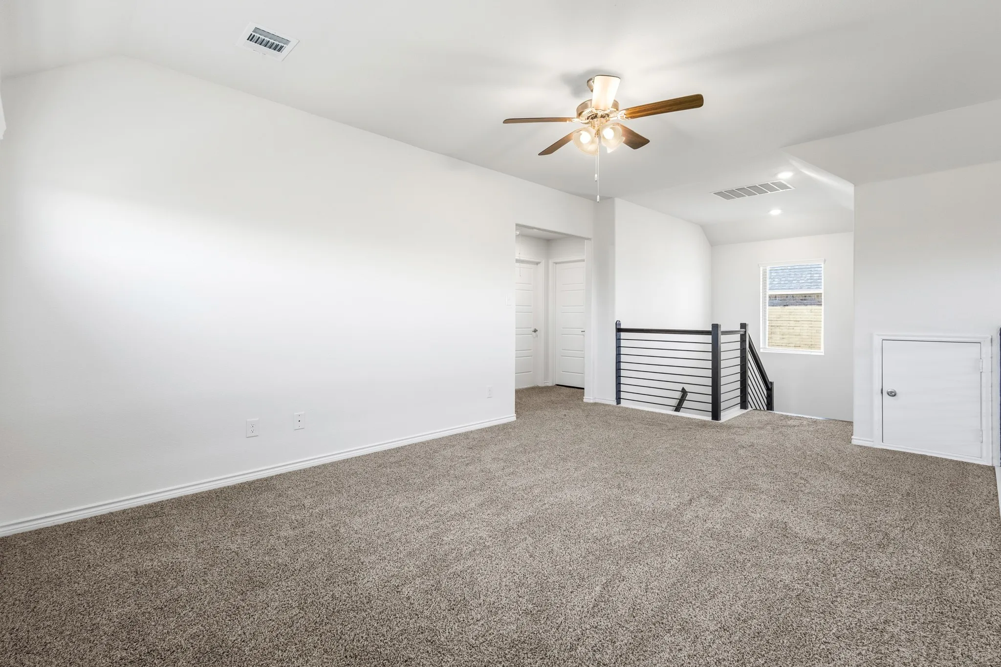 Spacious carpeted area with a ceiling fan and recessed lighting
