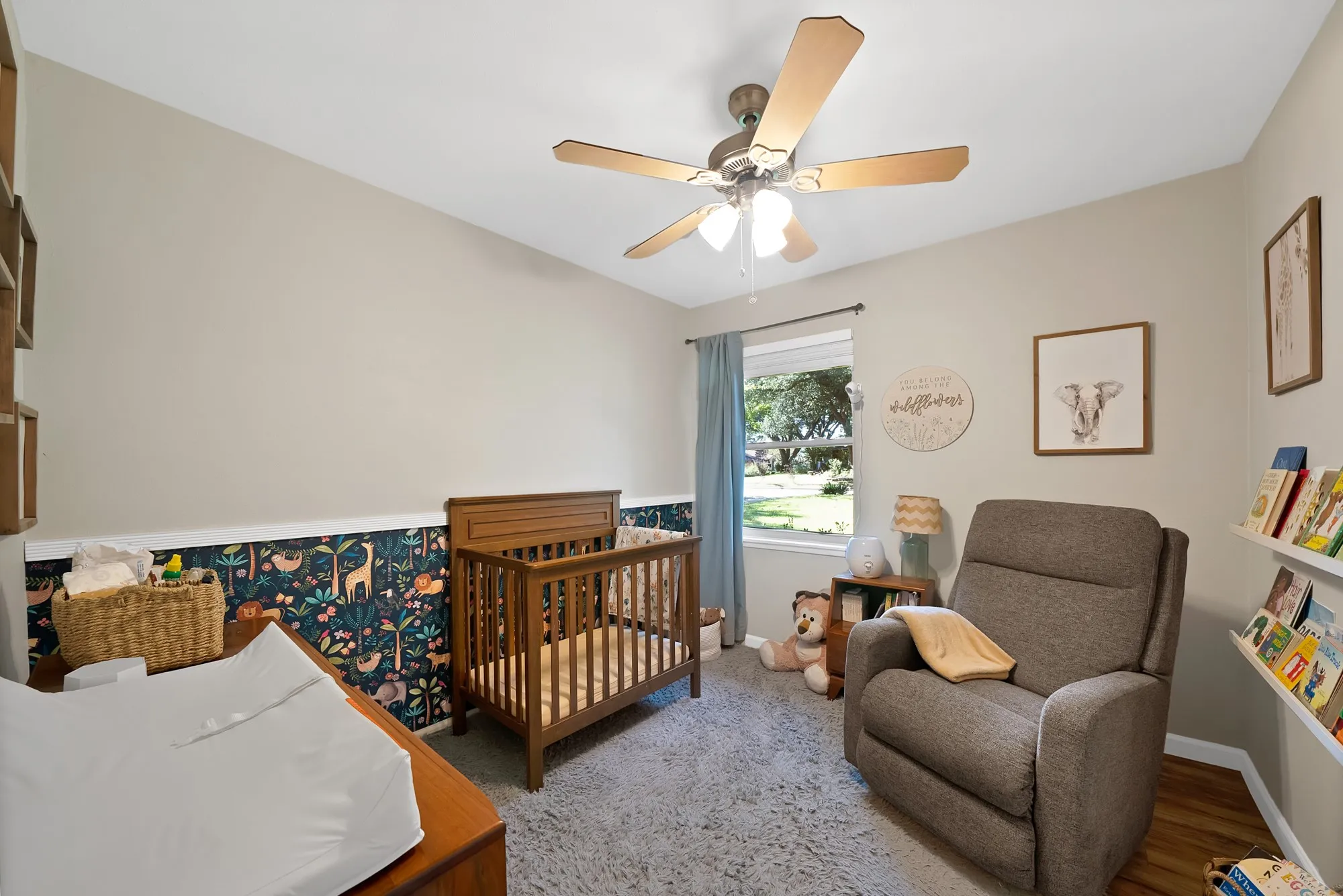 Bedroom with a crib and ceiling fan