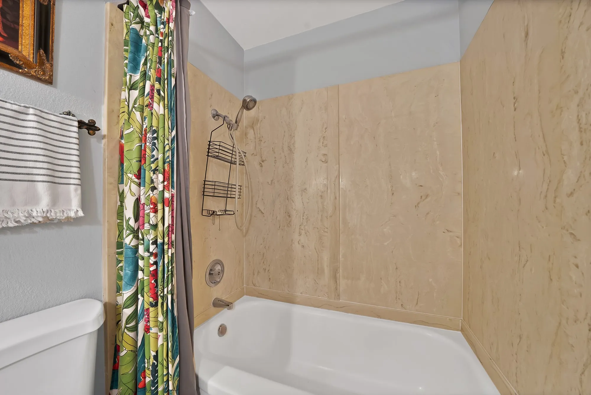 Full bath with shower / bath combo and a textured wall